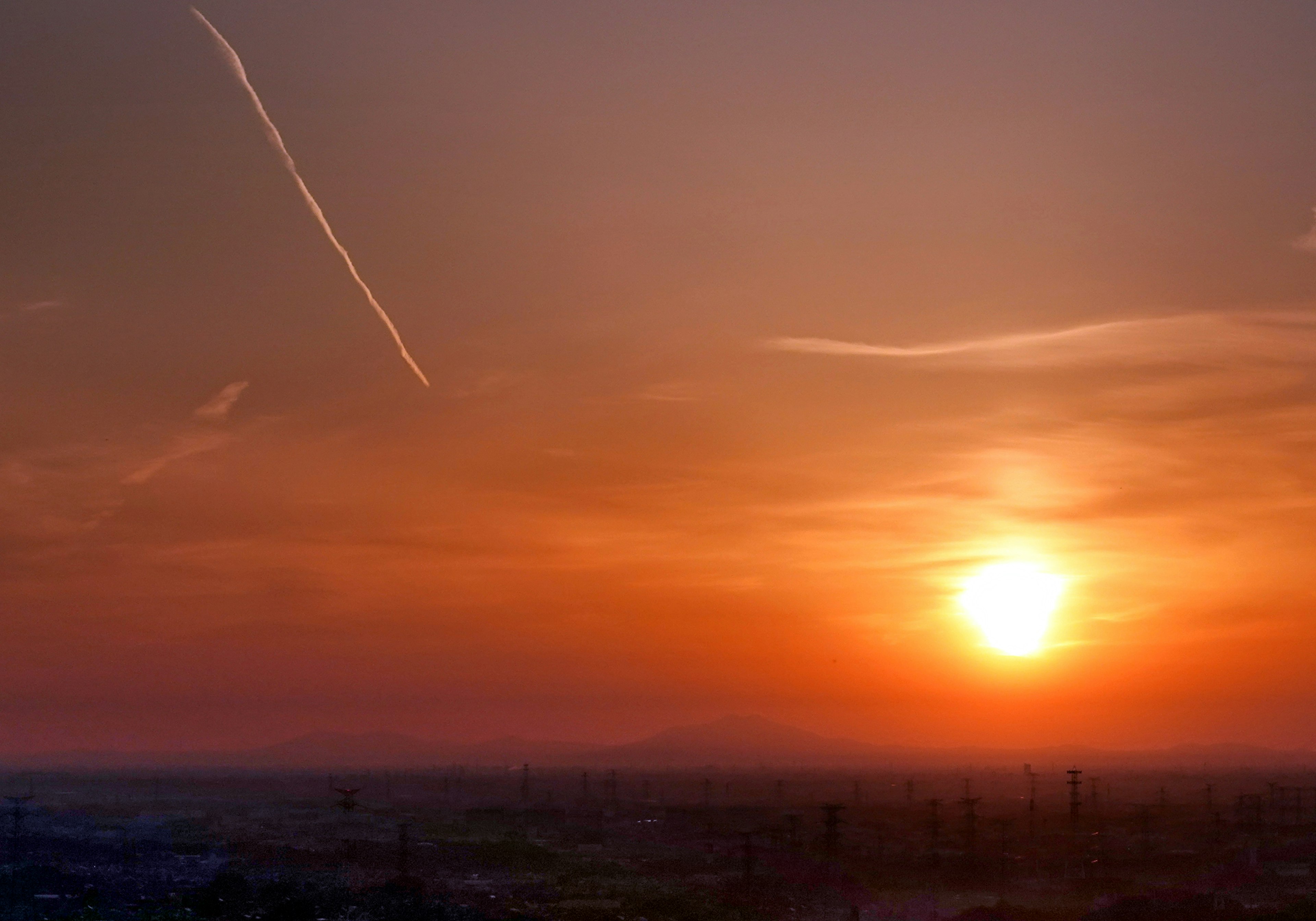 Atardecer sobre un cielo naranja vibrante con nubes suaves