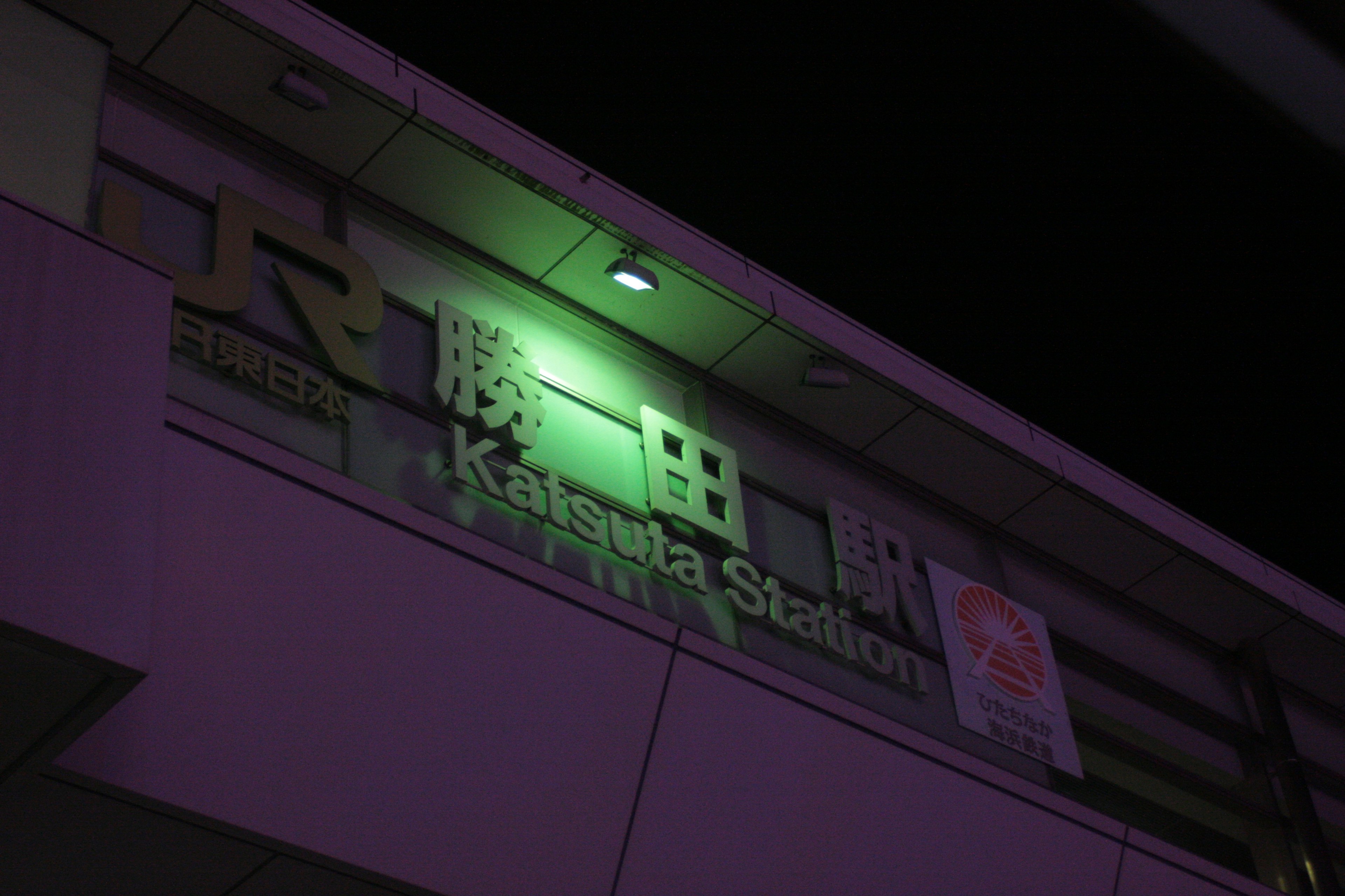 Night view of Kamata Station sign illuminated in green