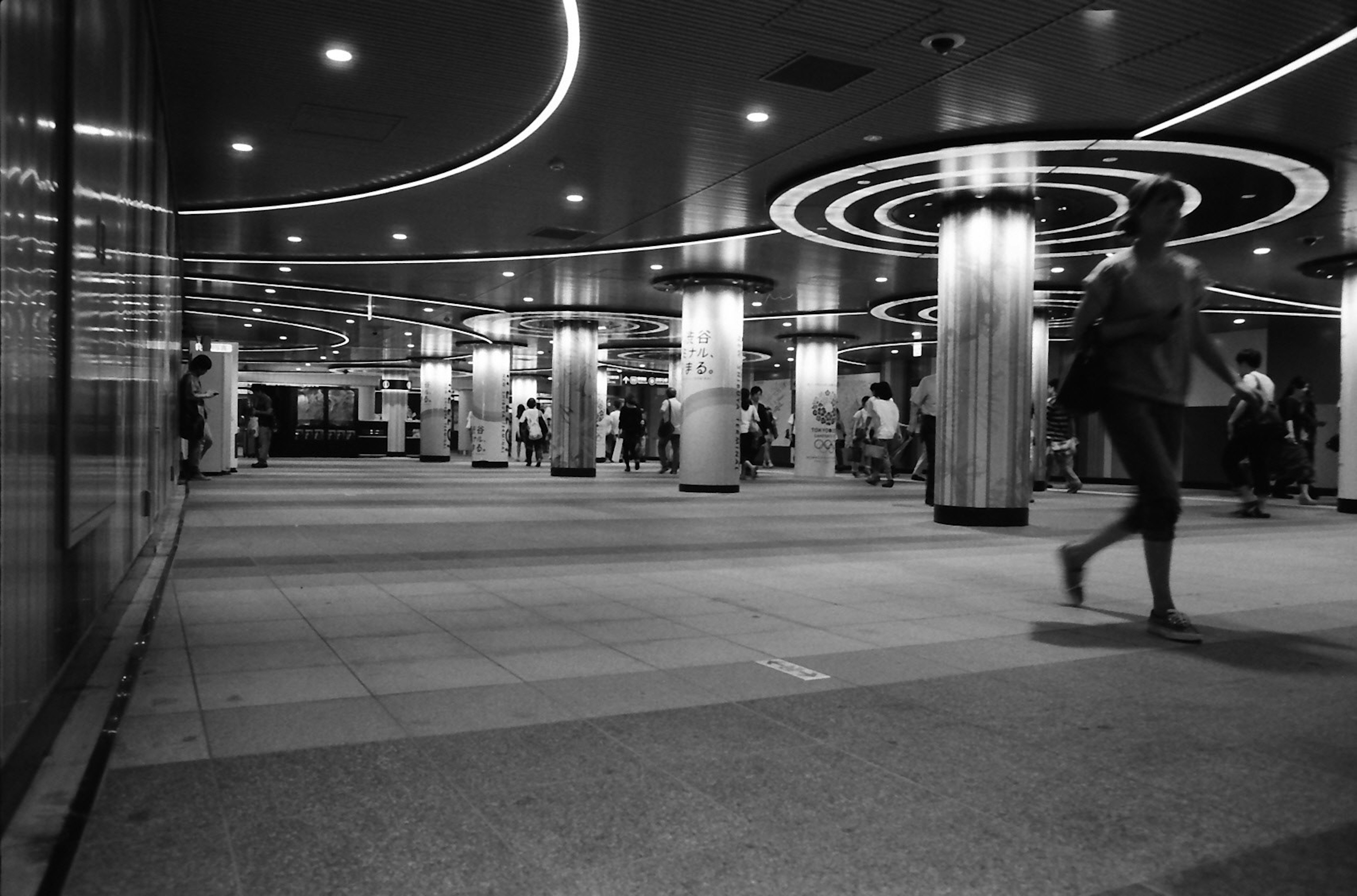 Modern subway station interior with bright lighting and people walking