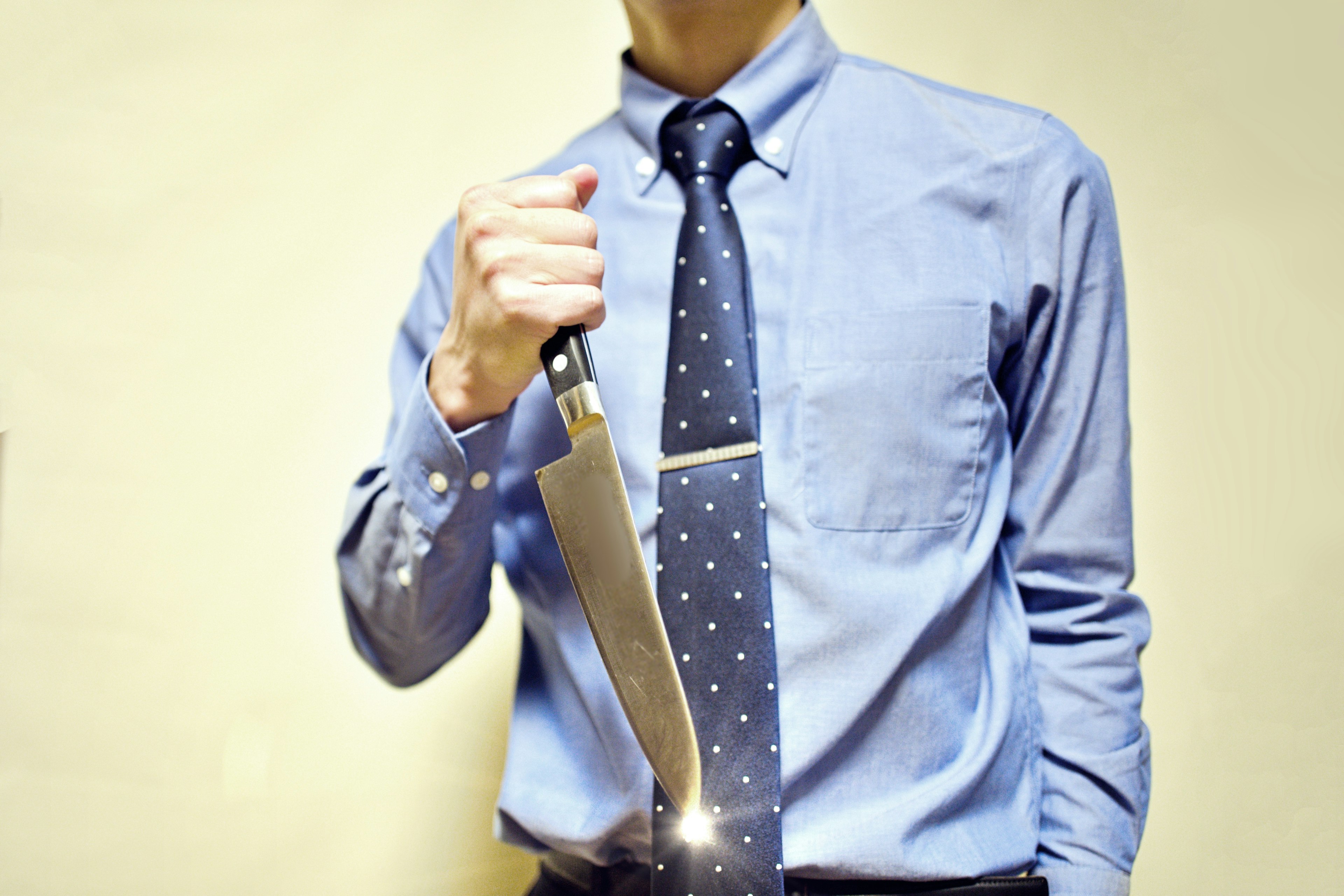 A man in a suit holding a knife