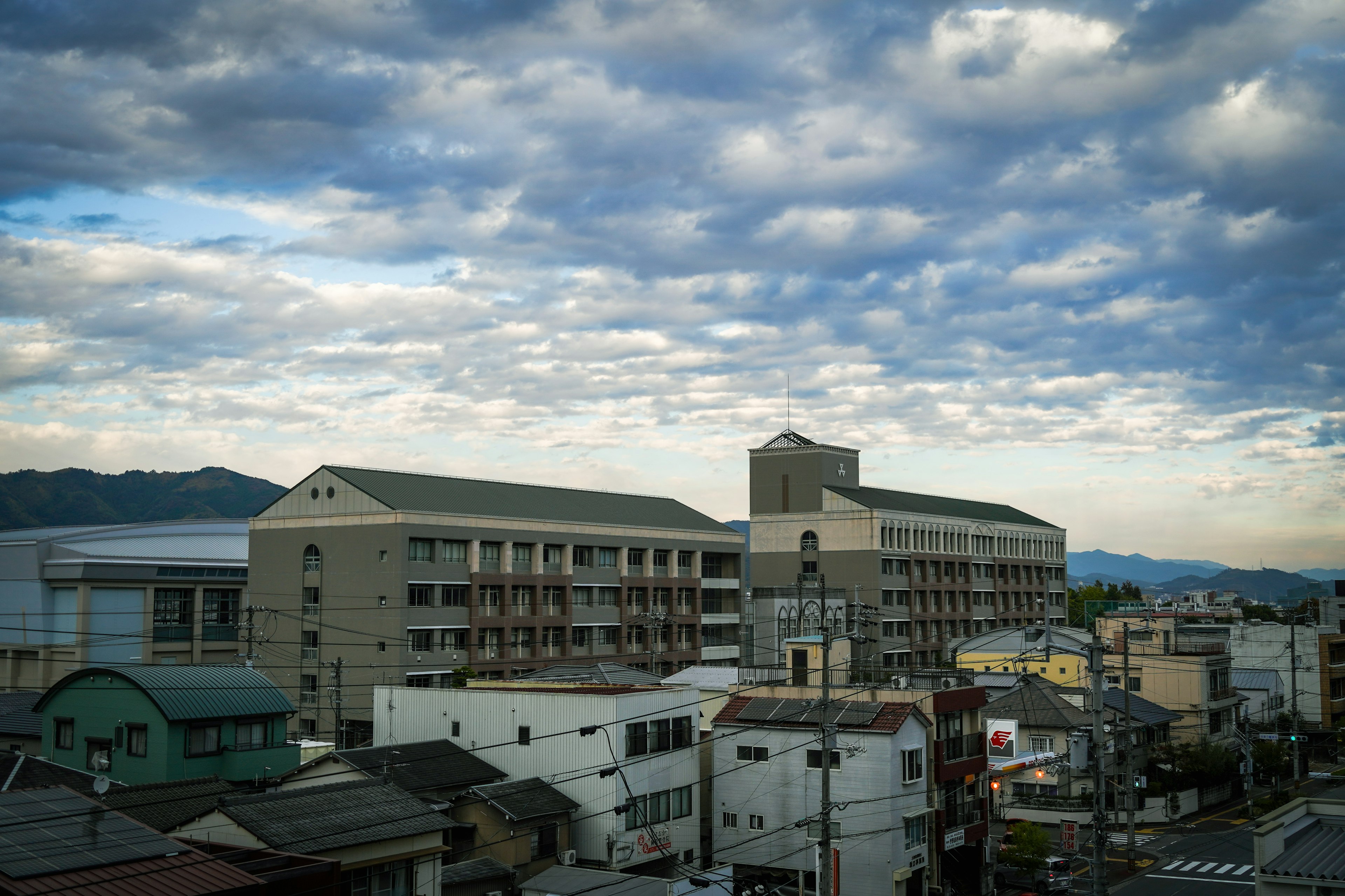 青空と雲が広がる風景に囲まれた都市の景観 住宅と商業ビルが立ち並ぶ