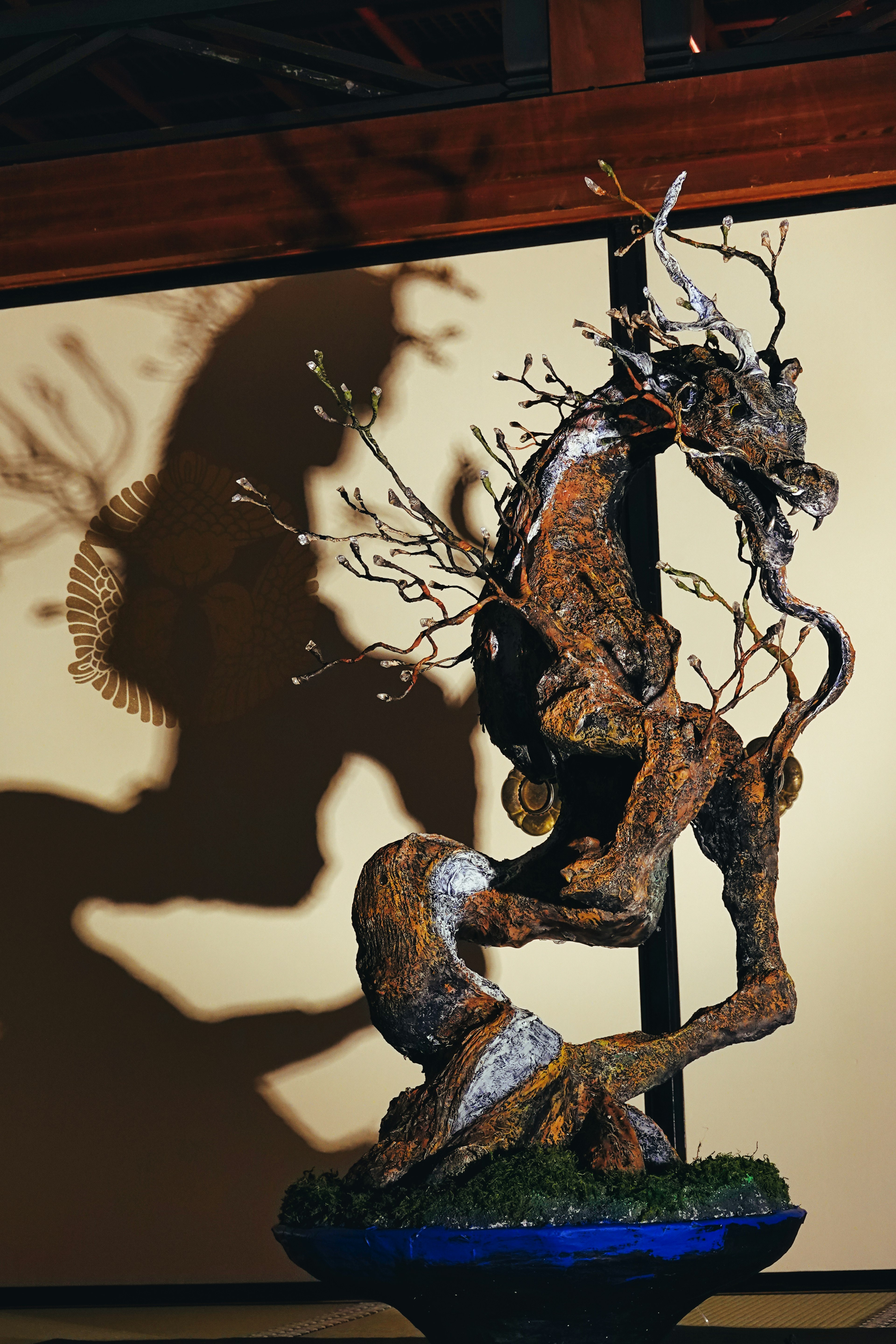 A sculpture resembling a dragon casting a shadow