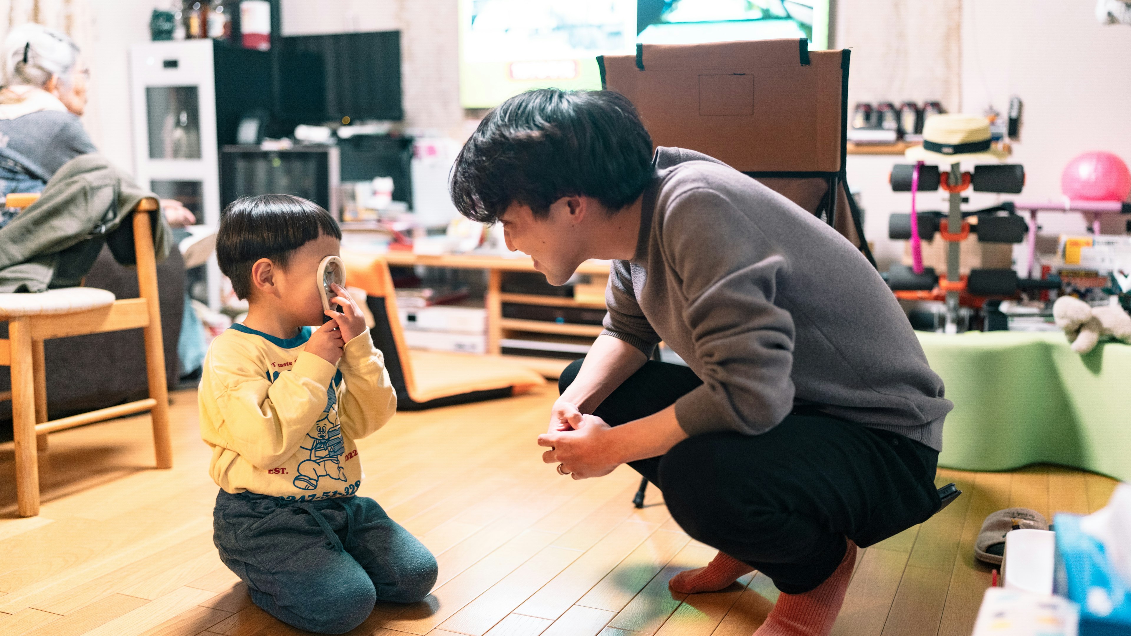 A child and an adult interacting playfully in a cozy living room