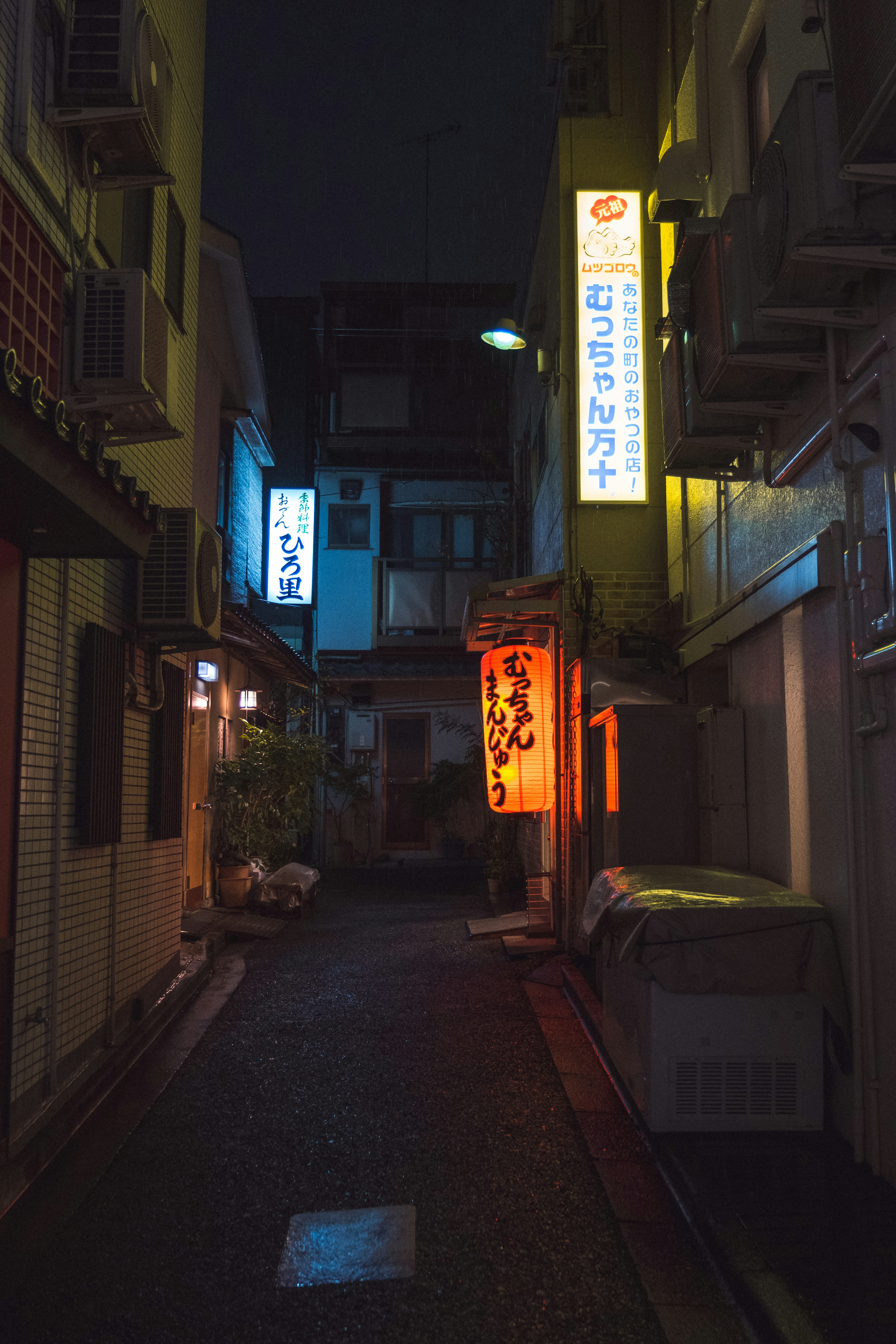 暗い路地にある看板と灯りが印象的な夜の街並み