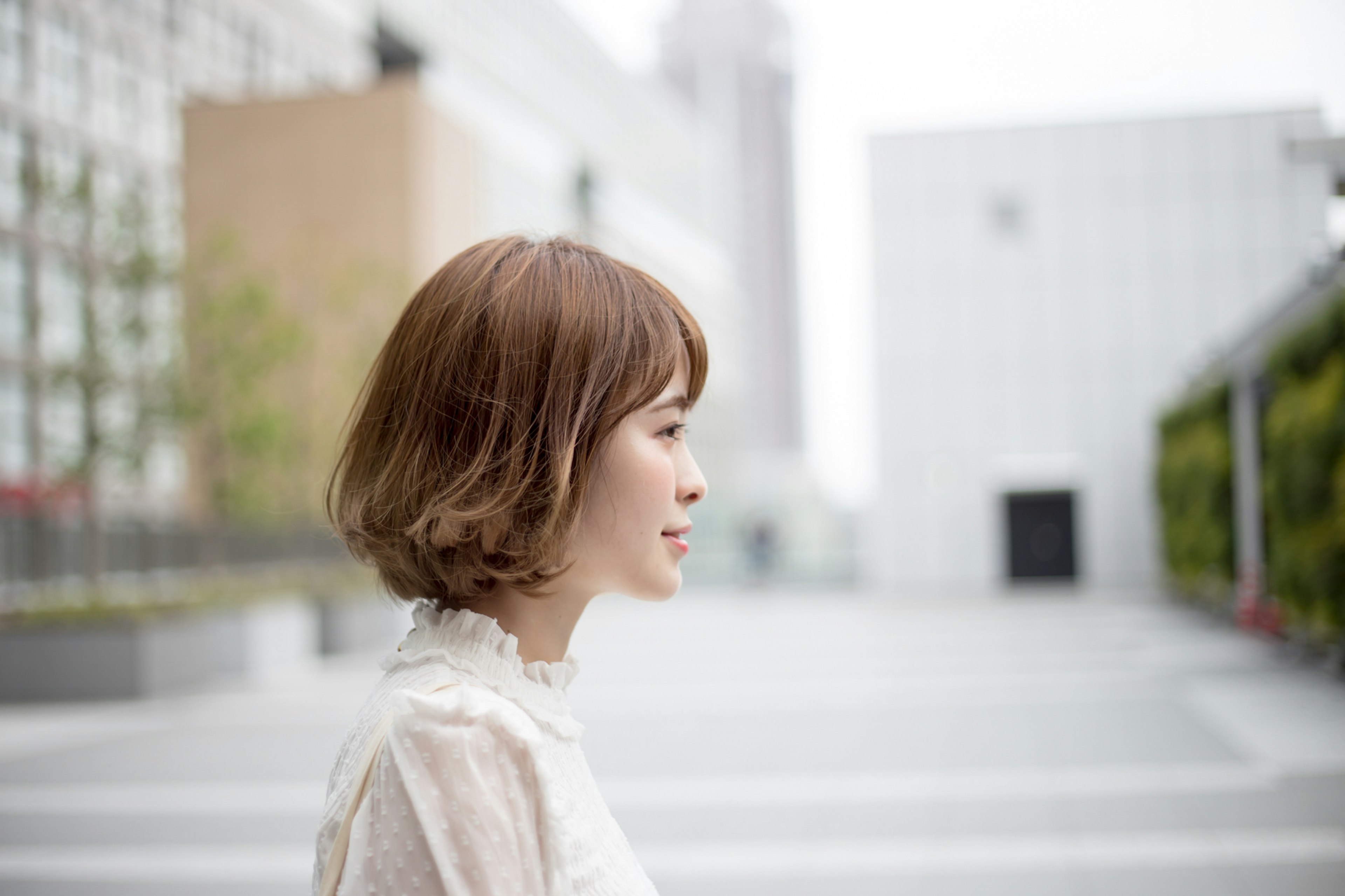 Profile of a woman standing in an urban setting