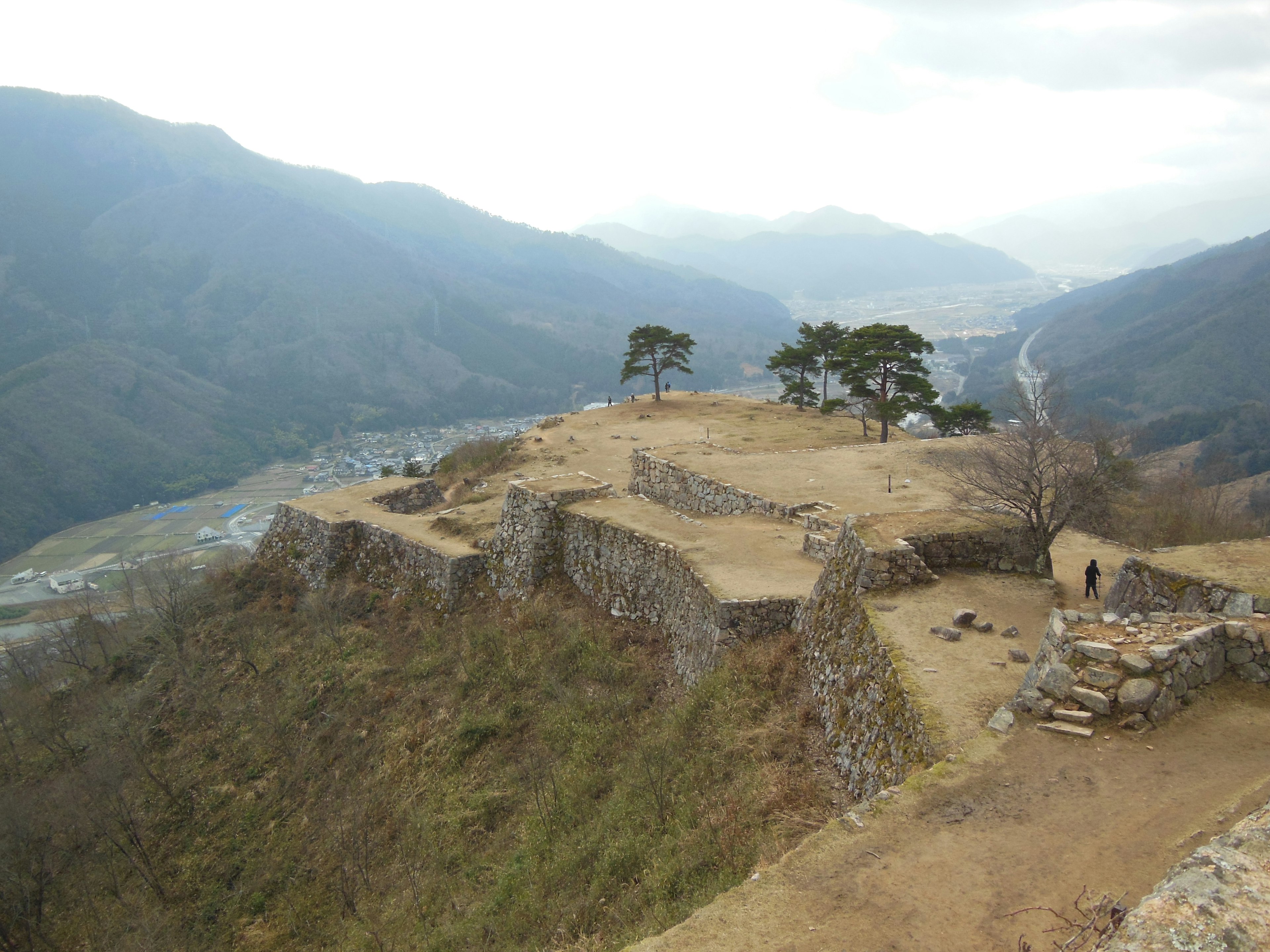 Ruines d'un ancien château sur une montagne avec un paysage environnant