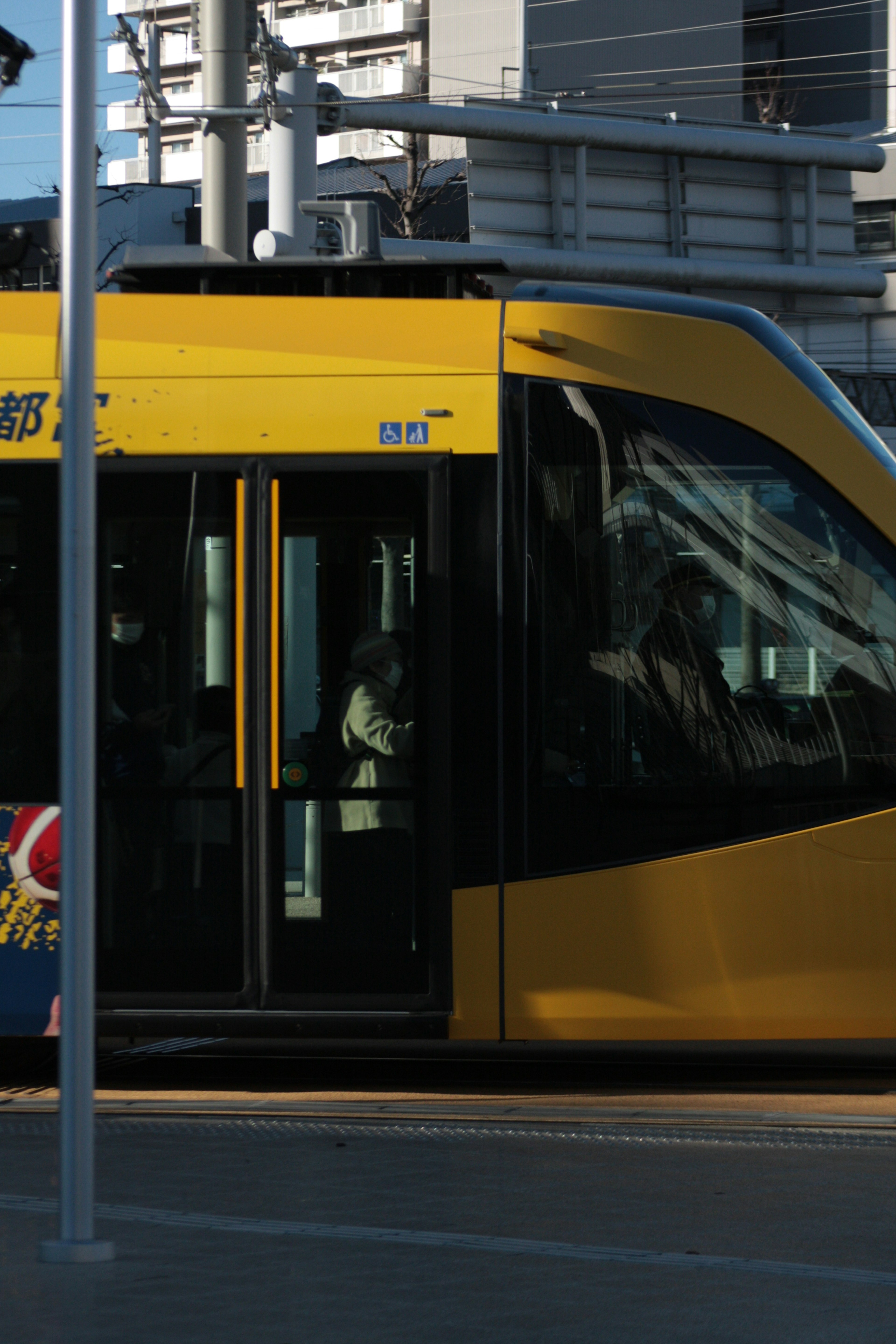 Un tram giallo che si ferma a una stazione