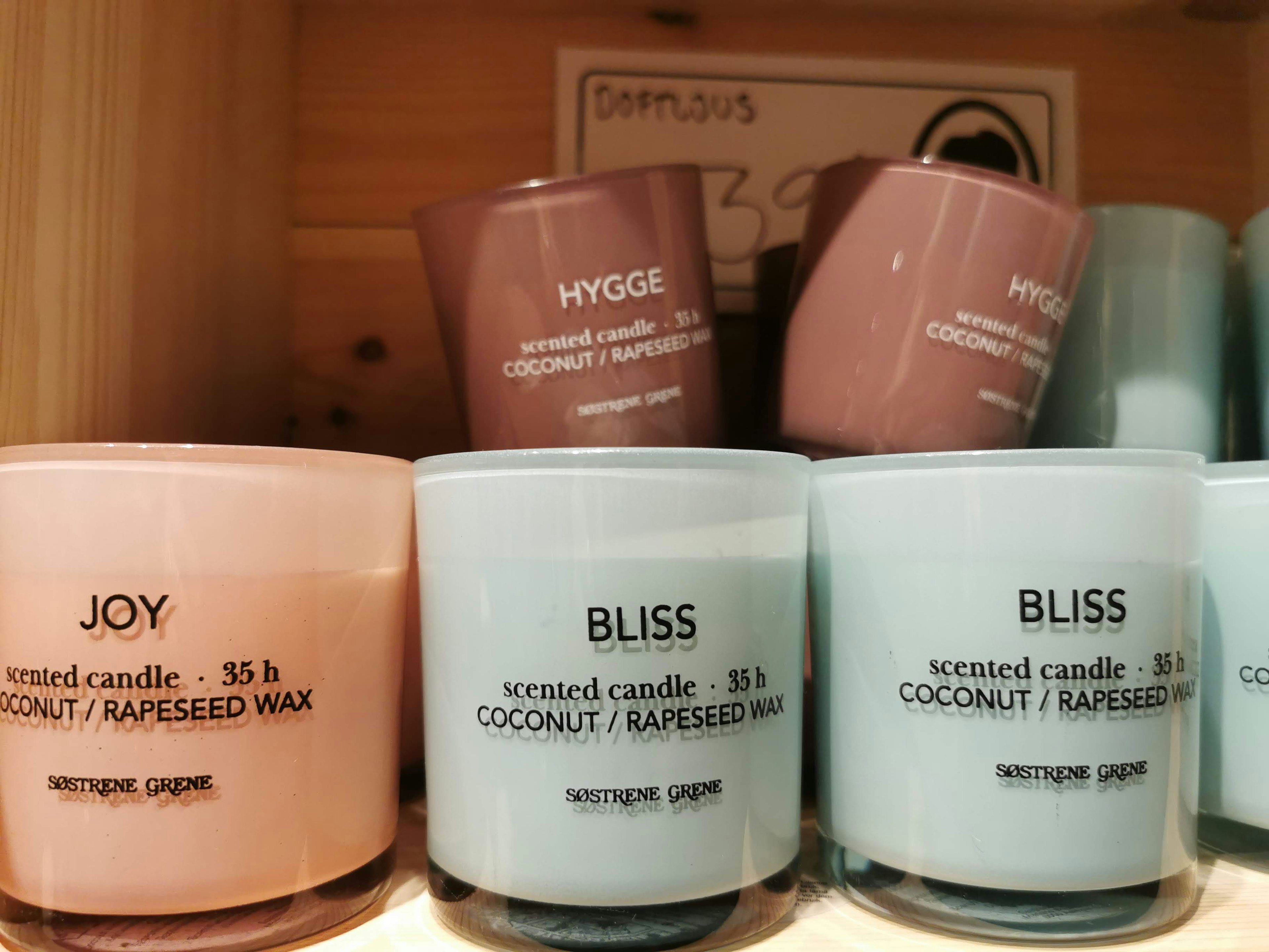 A collection of colorful scented candles displayed on a shelf