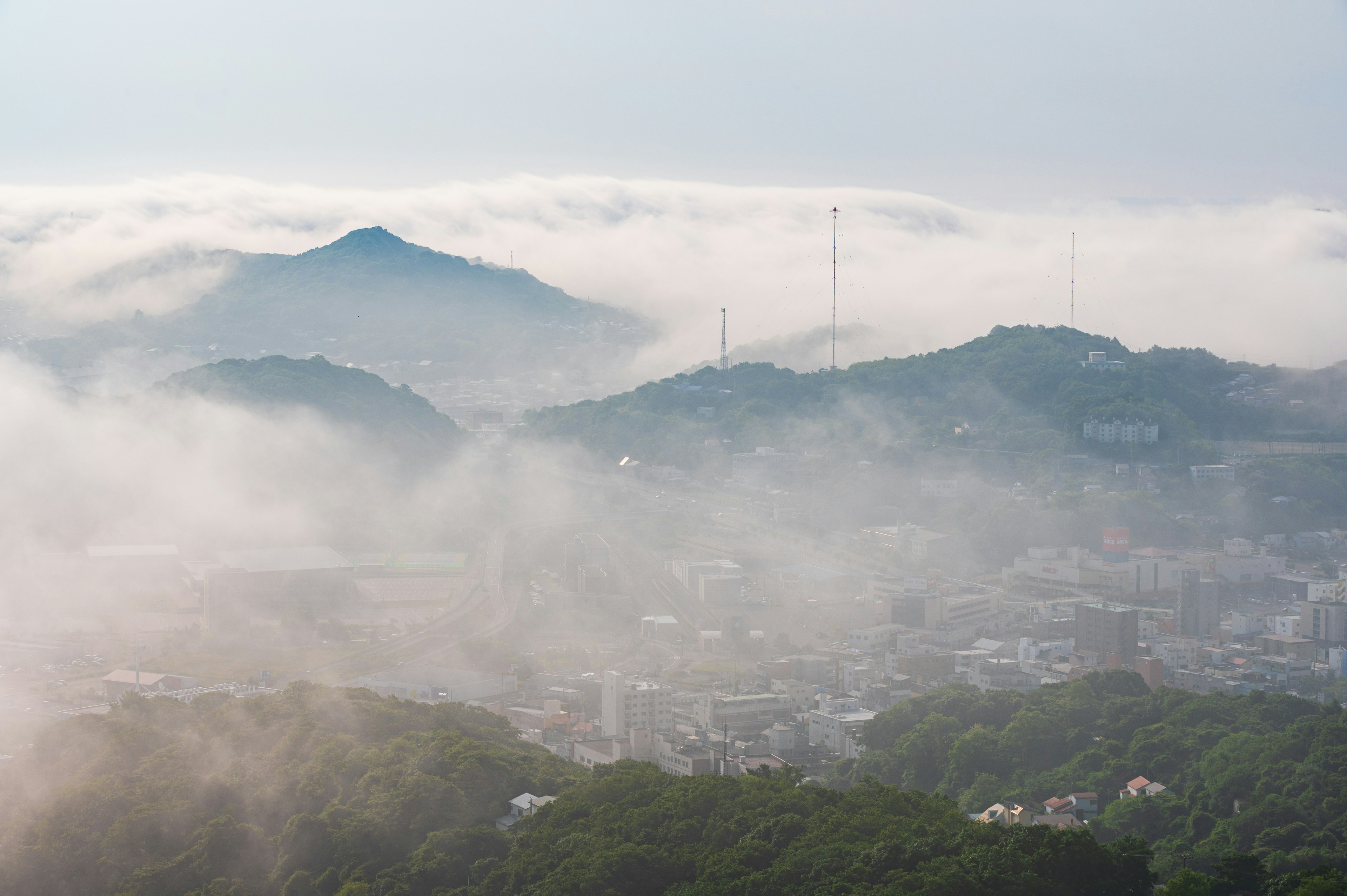 霧に包まれた山々の風景と街の光景