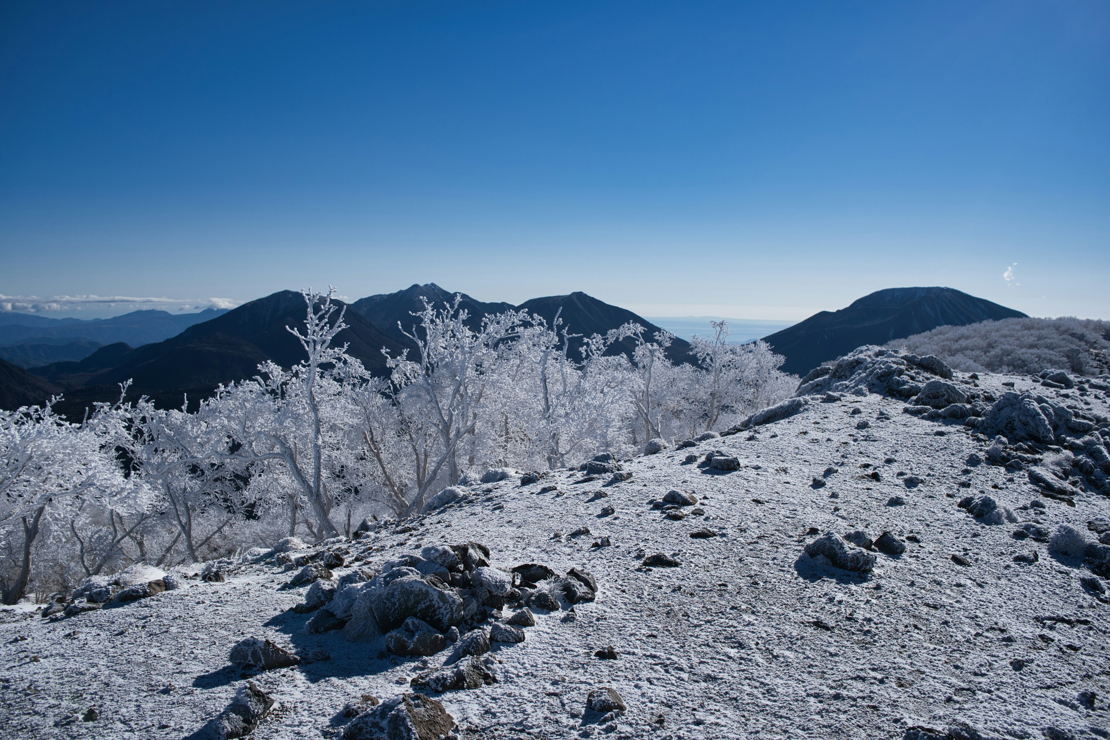 Snow-covered mountains under a clear blue sky