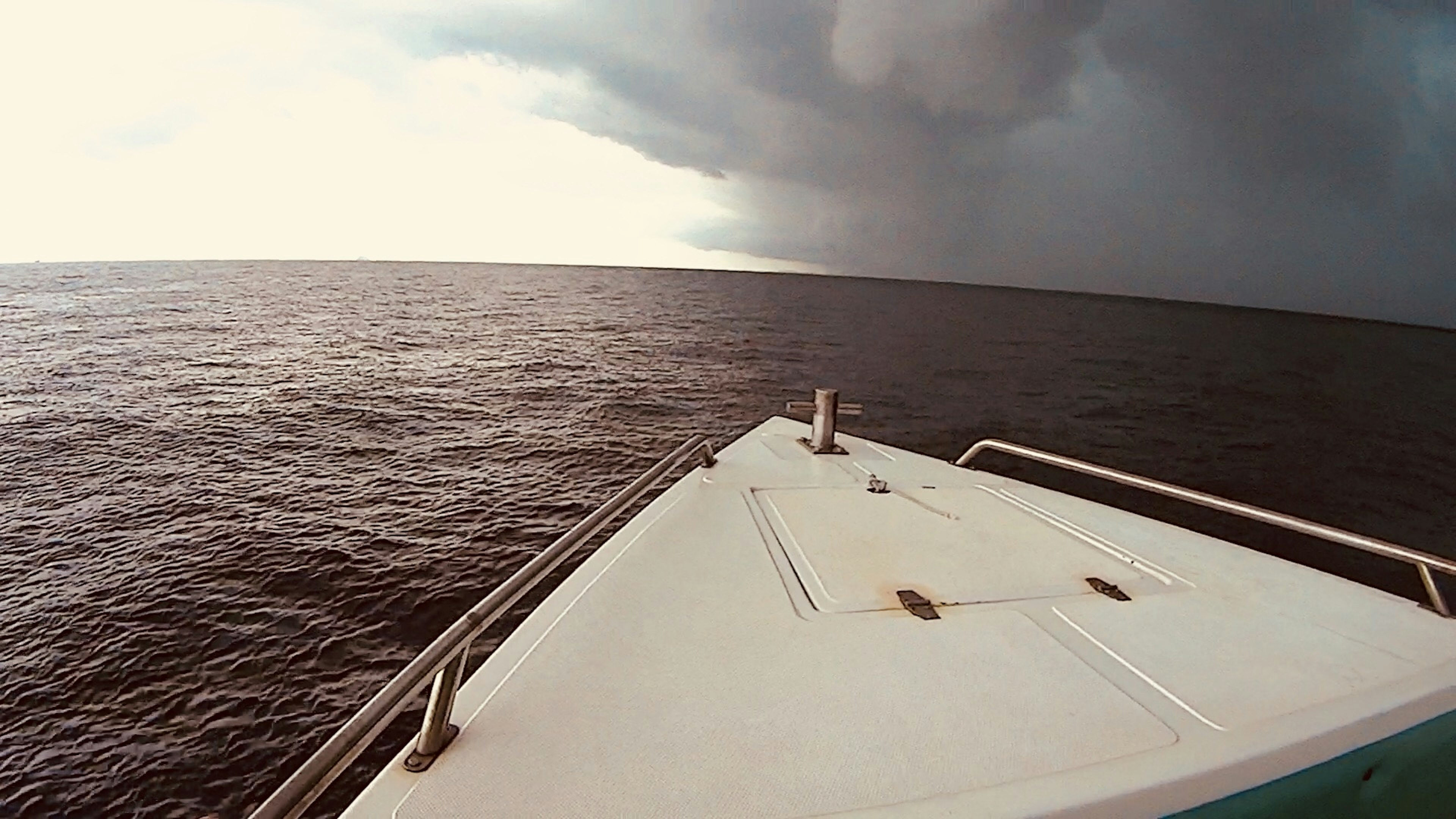 海の上の船の先端と暗い雲