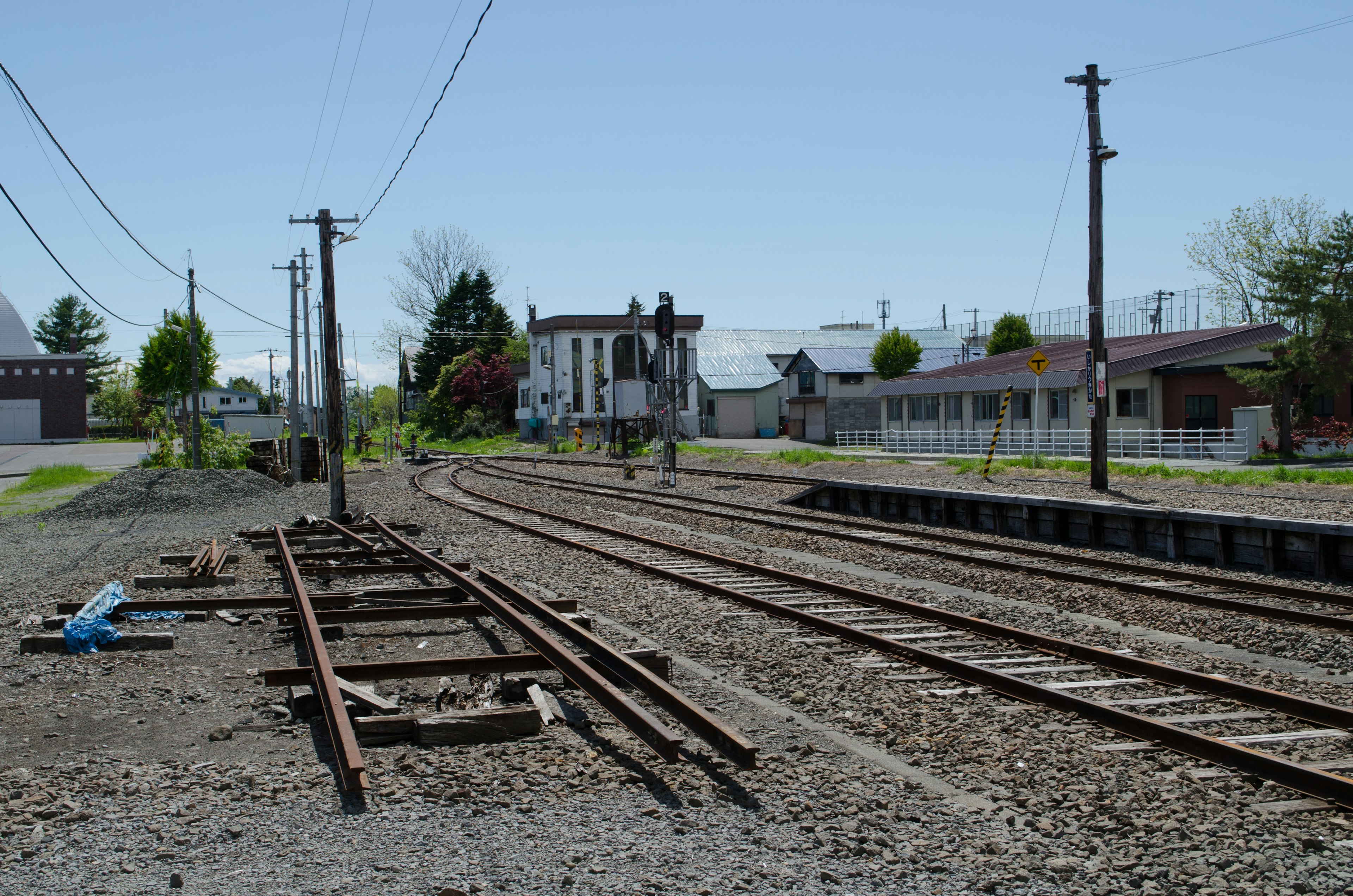 Scène de gare tranquille avec des voies ferrées et des bâtiments anciens