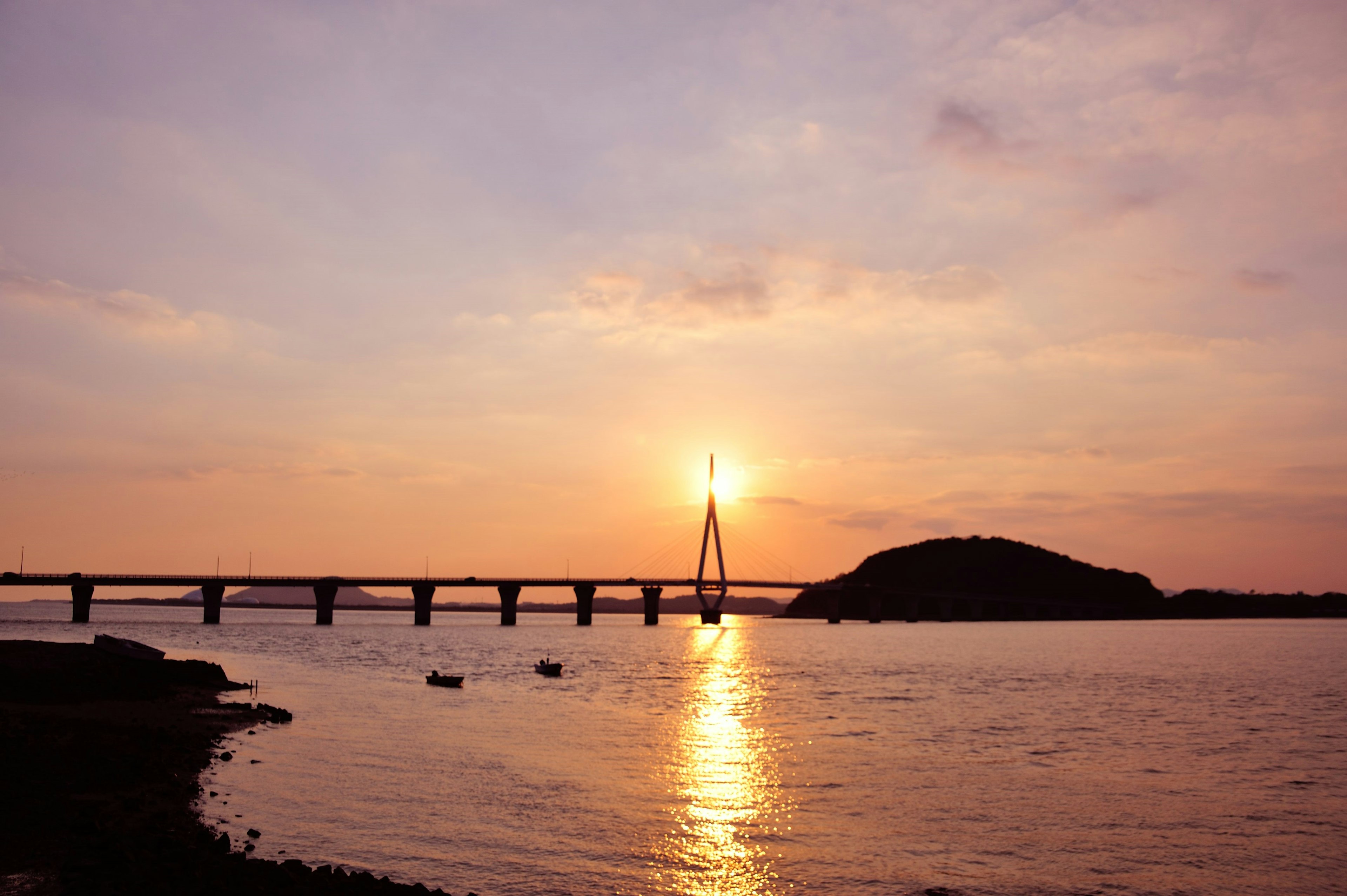 夕日が反射する川と橋の風景