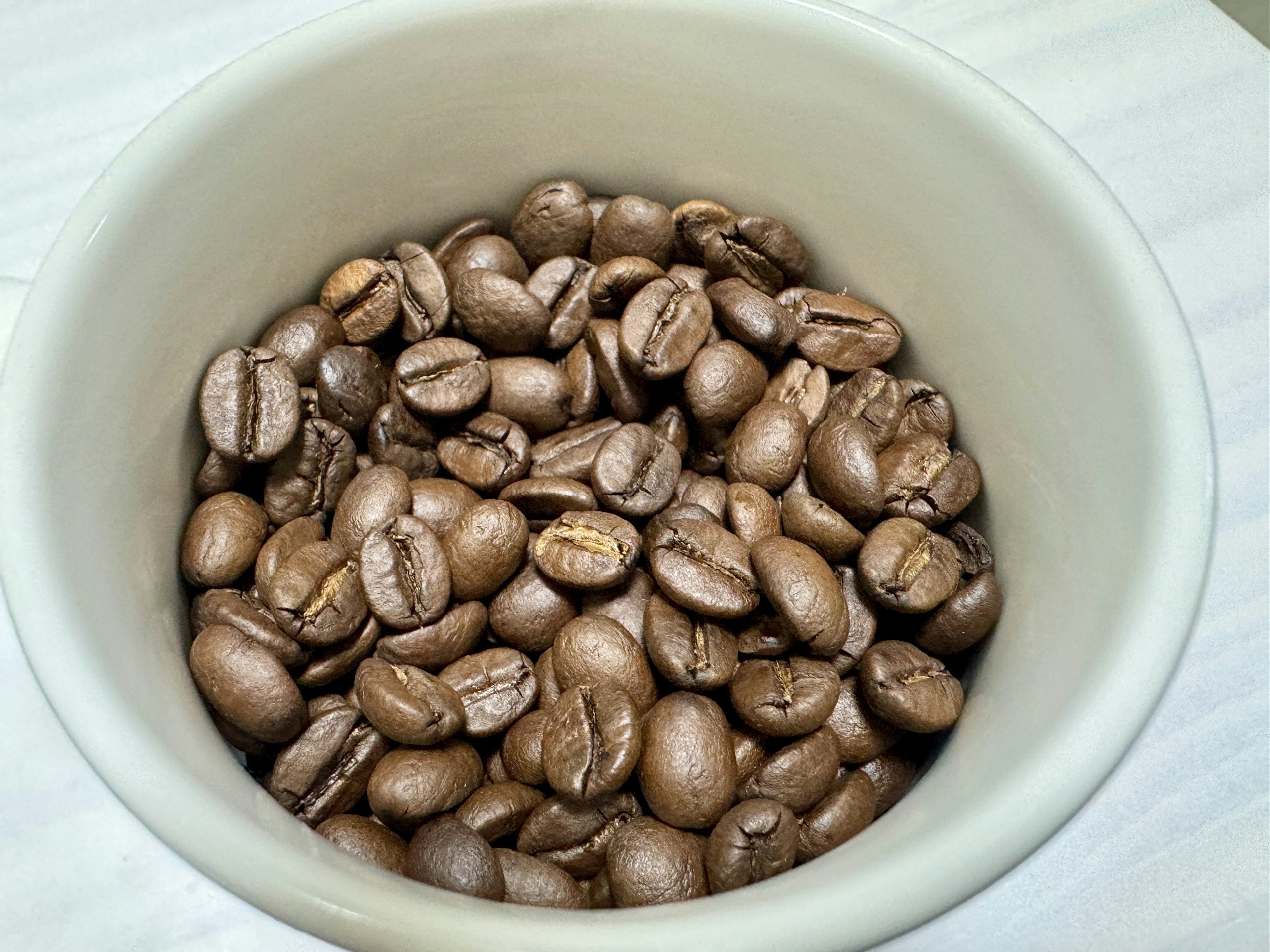 Gros plan de grains de café dans un bol blanc