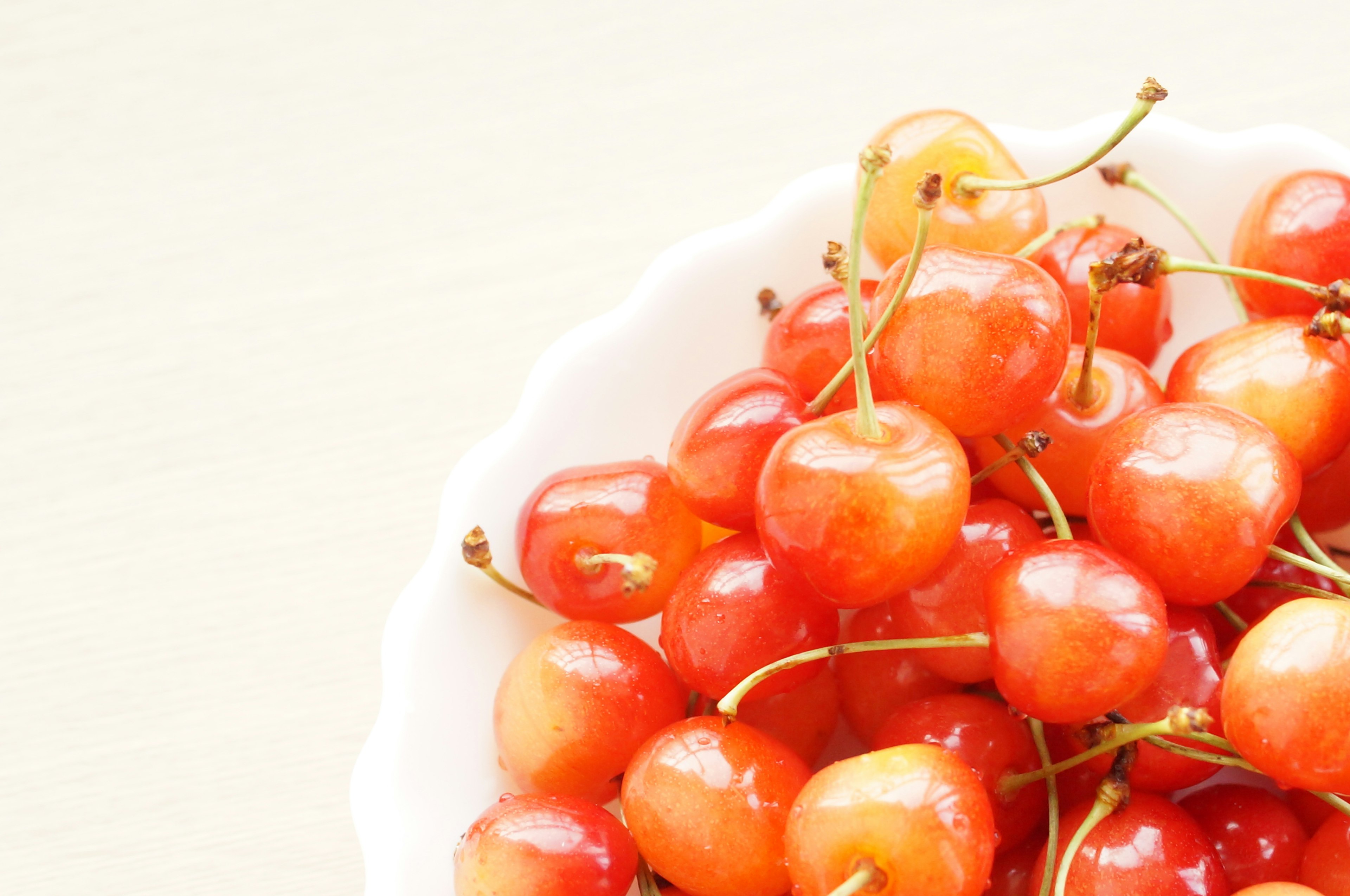 Close-up of red cherries in a white bowl