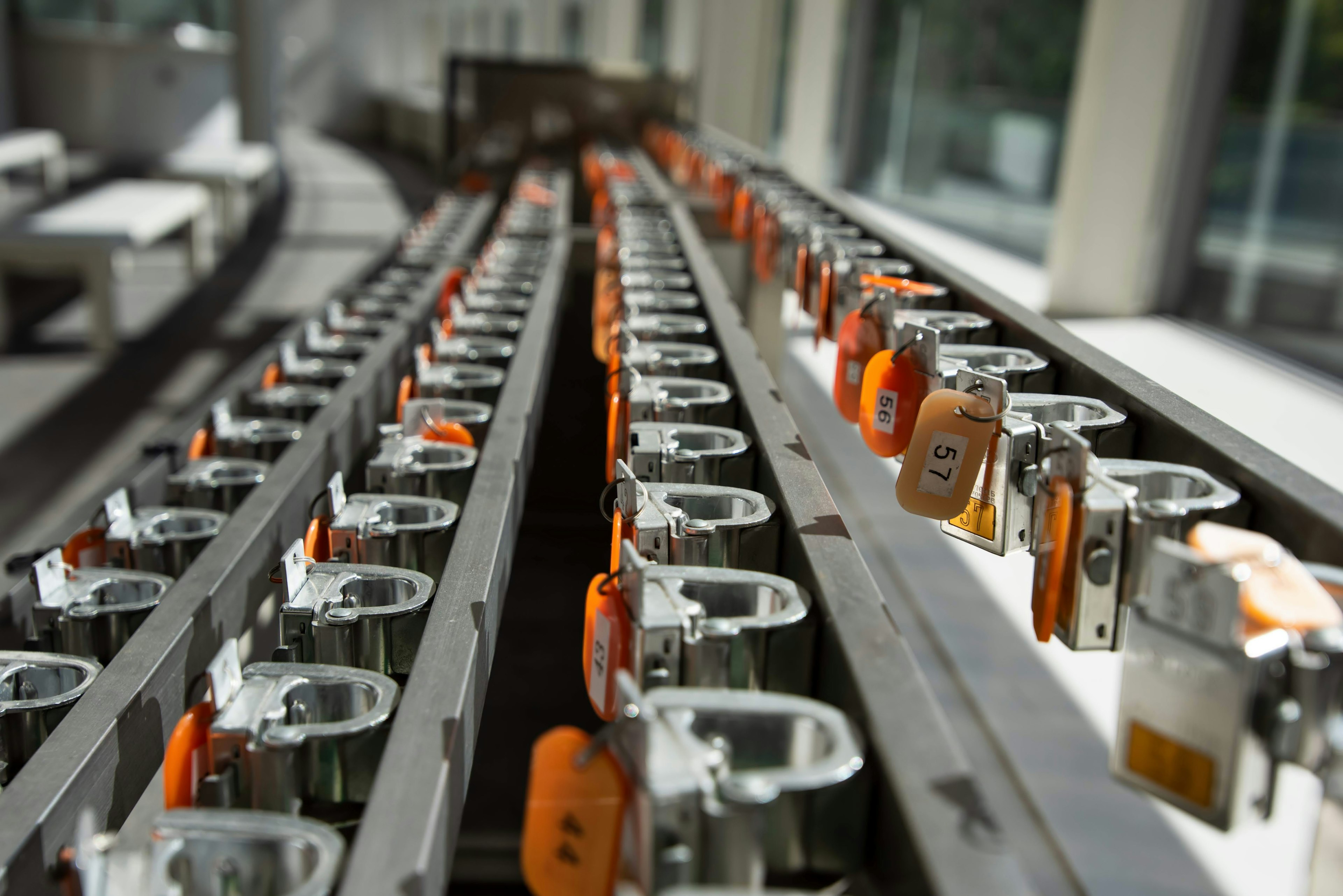 Image d'une rangée de casiers métalliques dans un environnement d'usine avec des cadenas orange