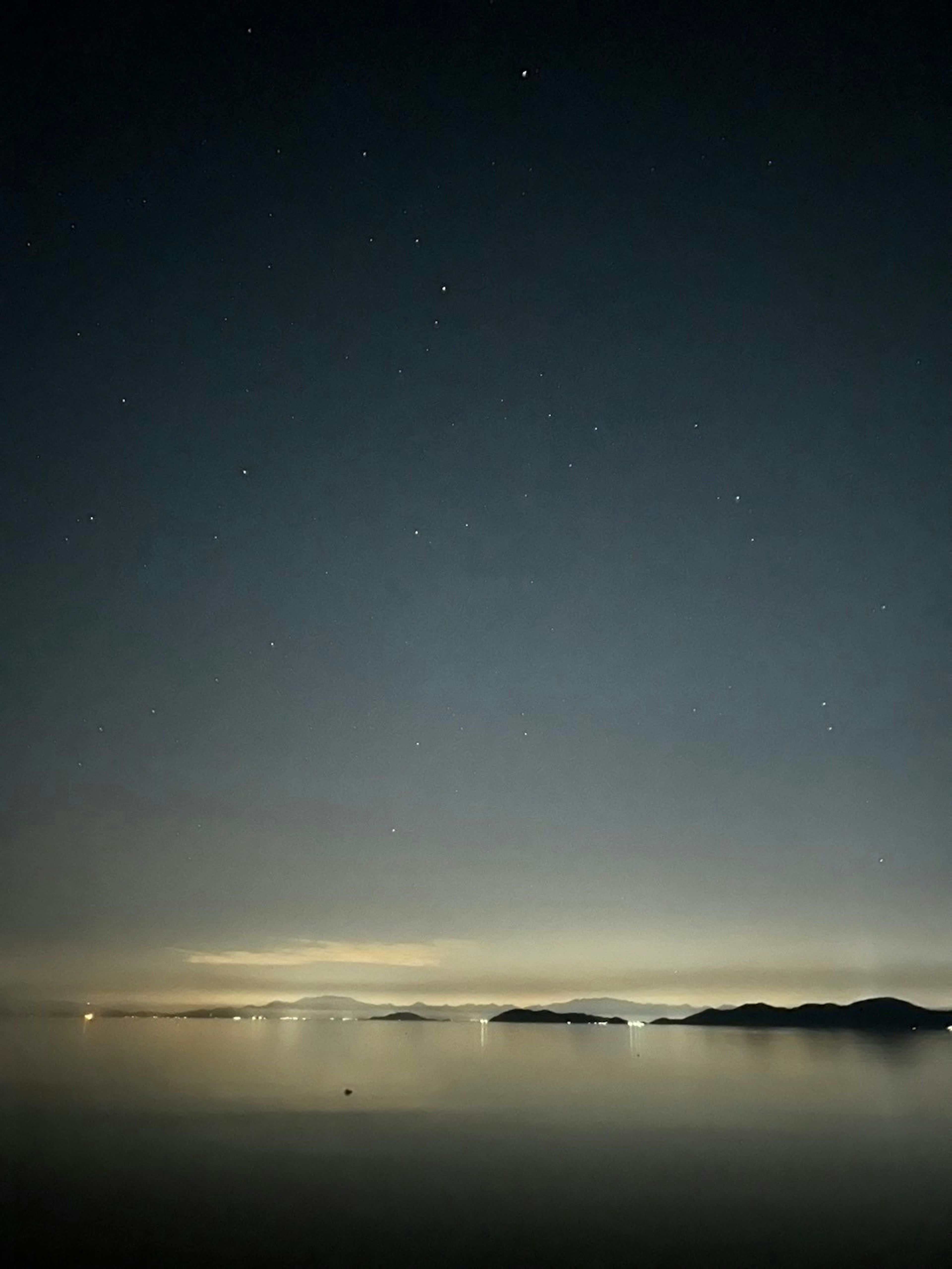 夜空に星が輝く静かな海の風景