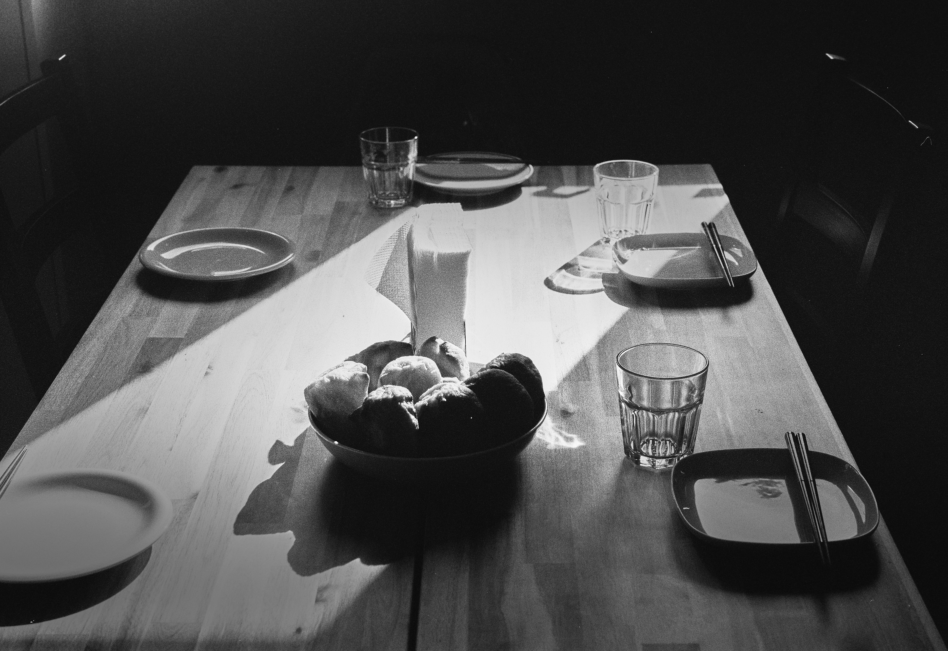 Une scène avec un bol de fruits et un ensemble de plats sur une table