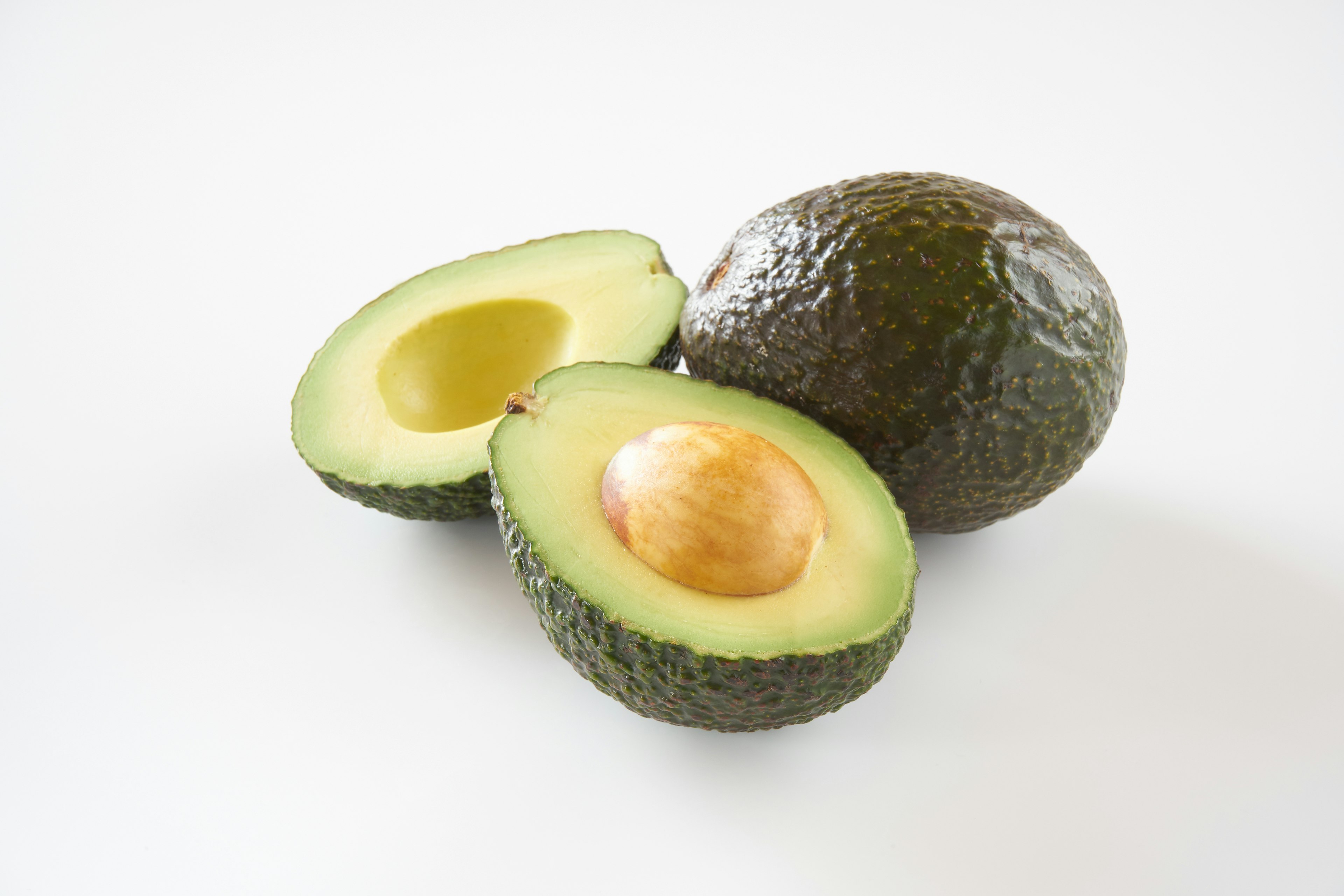 Avocado affettato con un avocado intero accanto