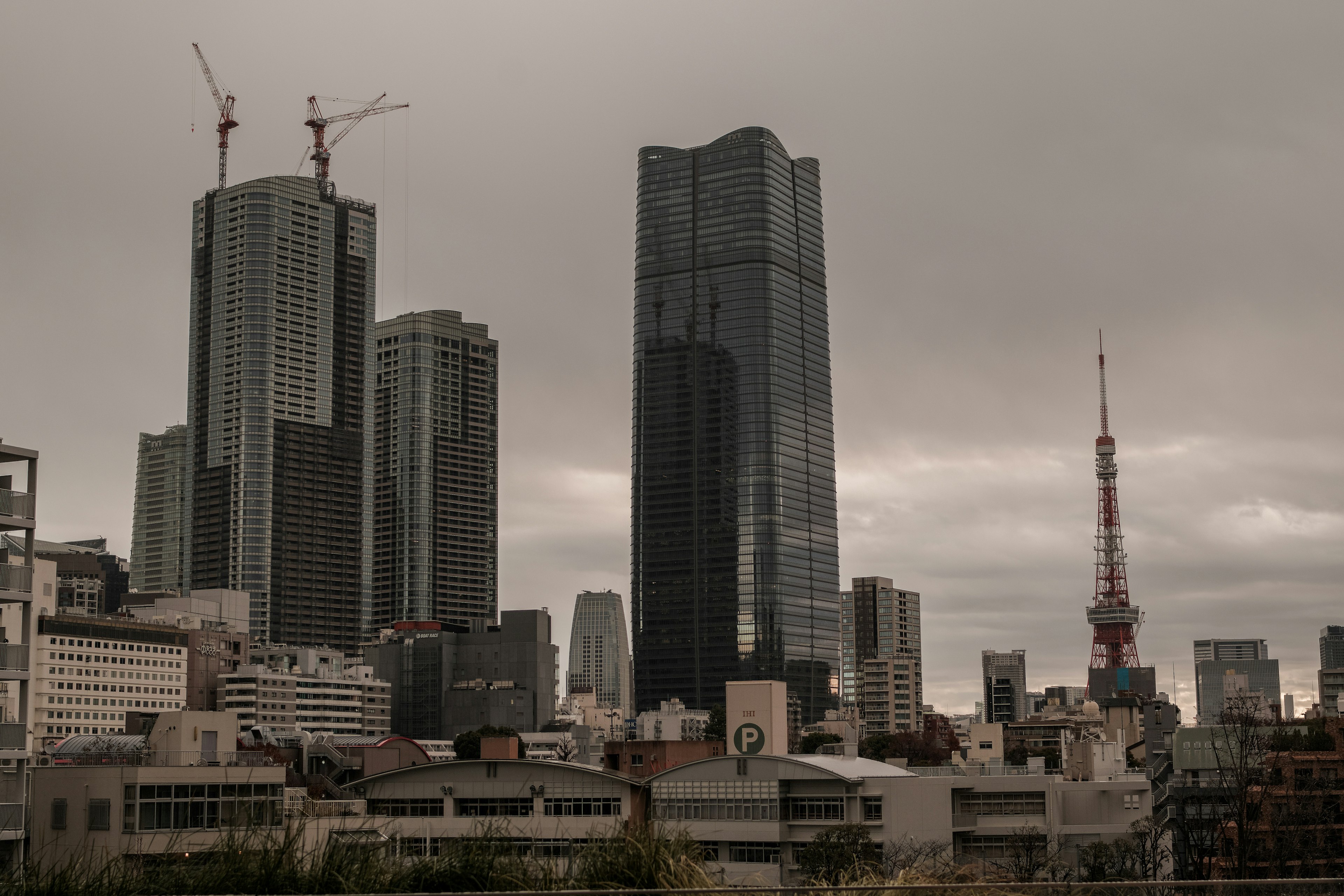 Khung cảnh thành phố với các tòa nhà chọc trời và Tháp Tokyo dưới bầu trời nhiều mây