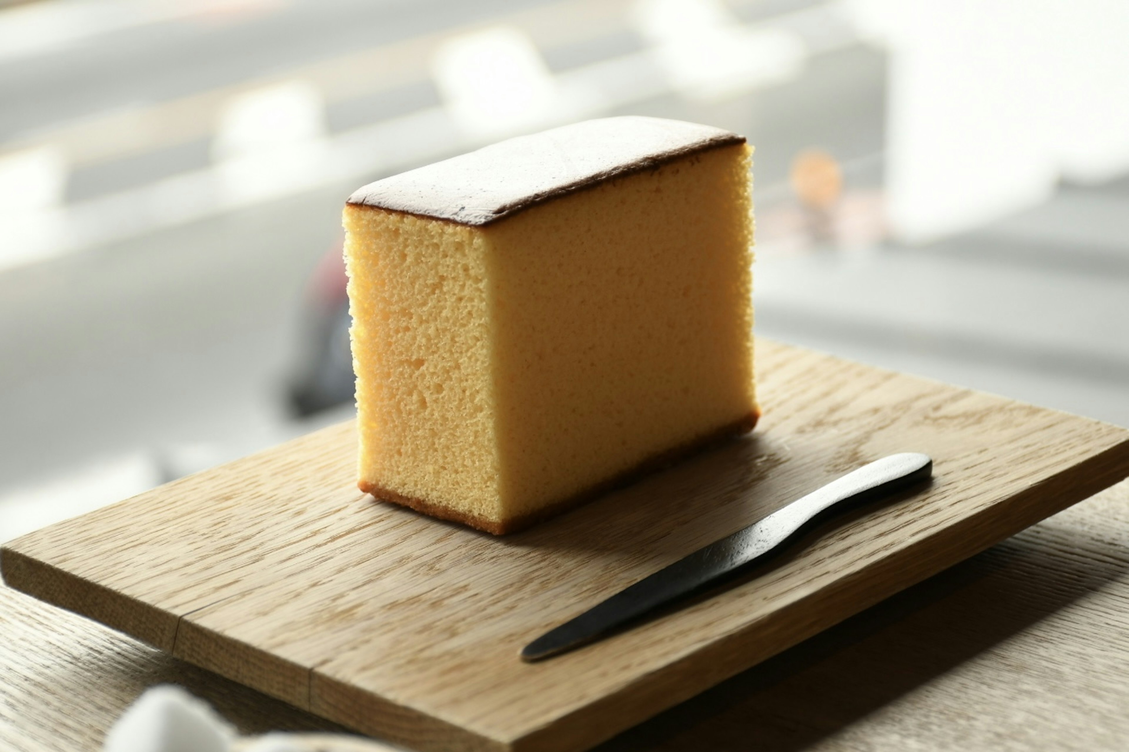 Pastel de castella amarillo en un plato de madera