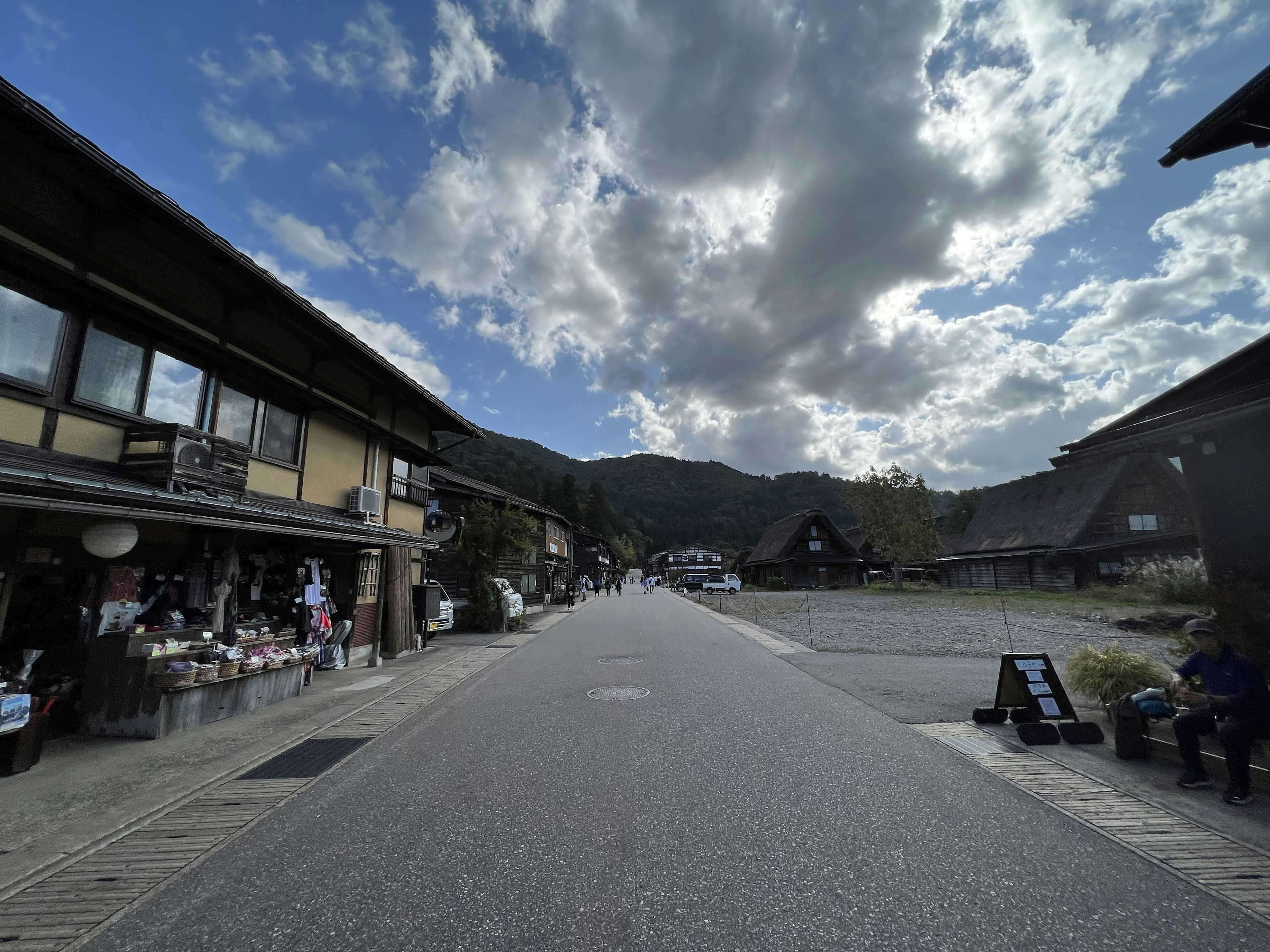 Calle tranquila bordeada de edificios japoneses tradicionales y montañas al fondo