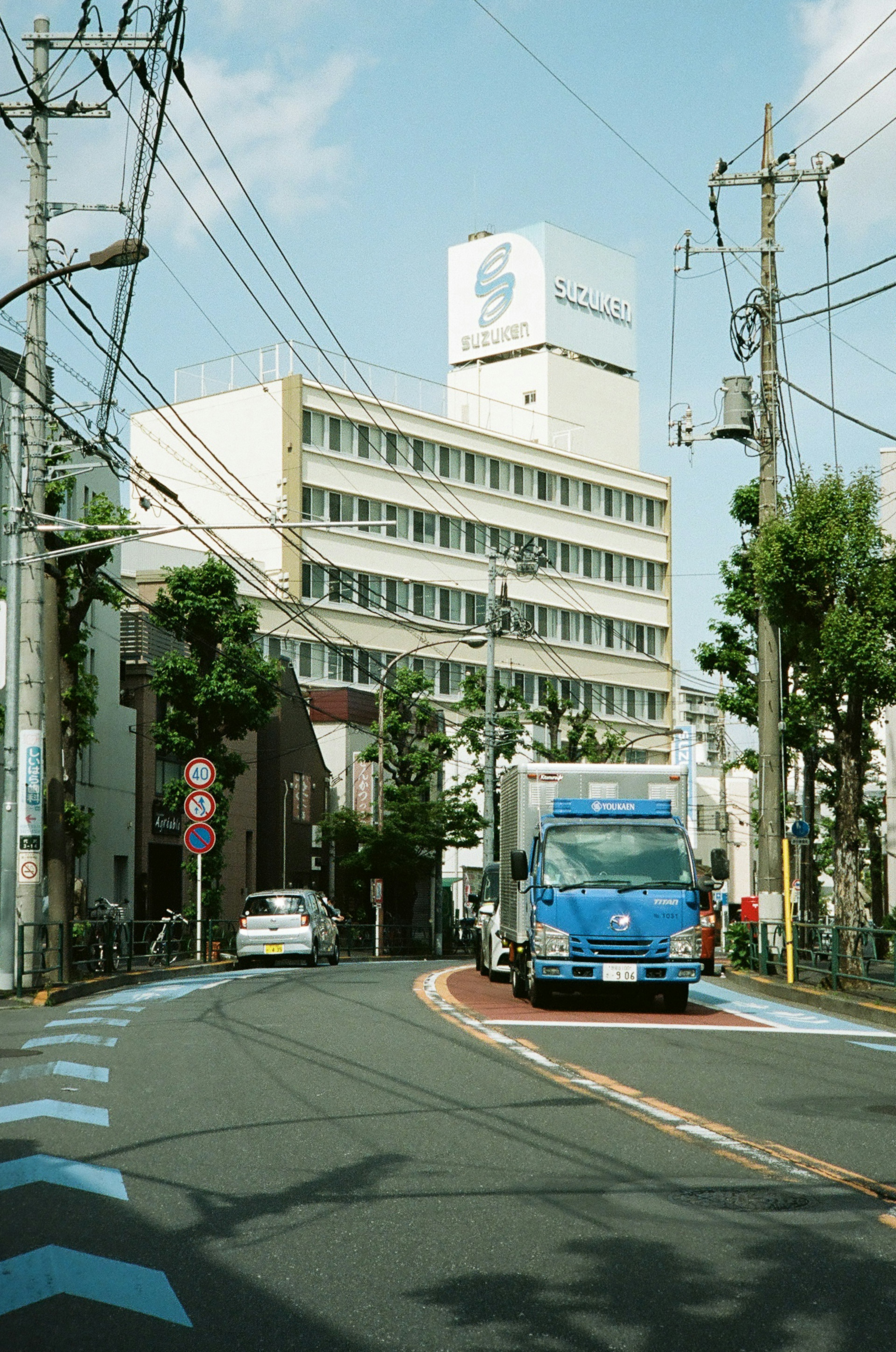 卡车在弯曲的道路上行驶，周围有建筑和电线