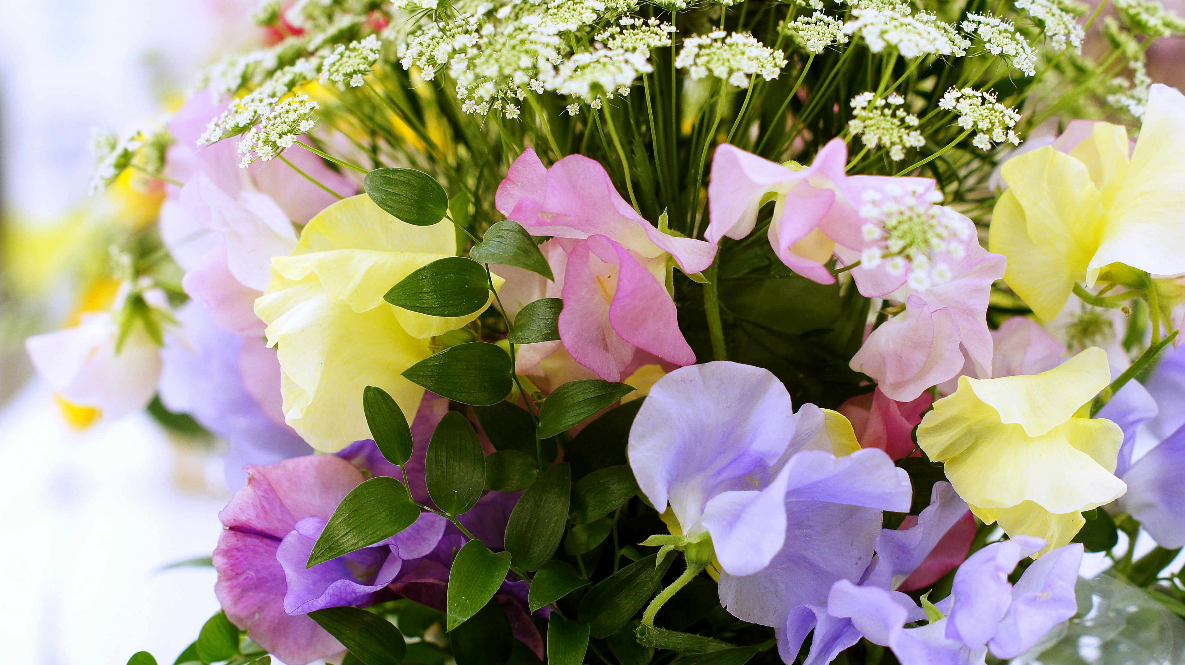 色とりどりの花のブーケ 黄色とピンクの花々と白い小さな花の組み合わせ