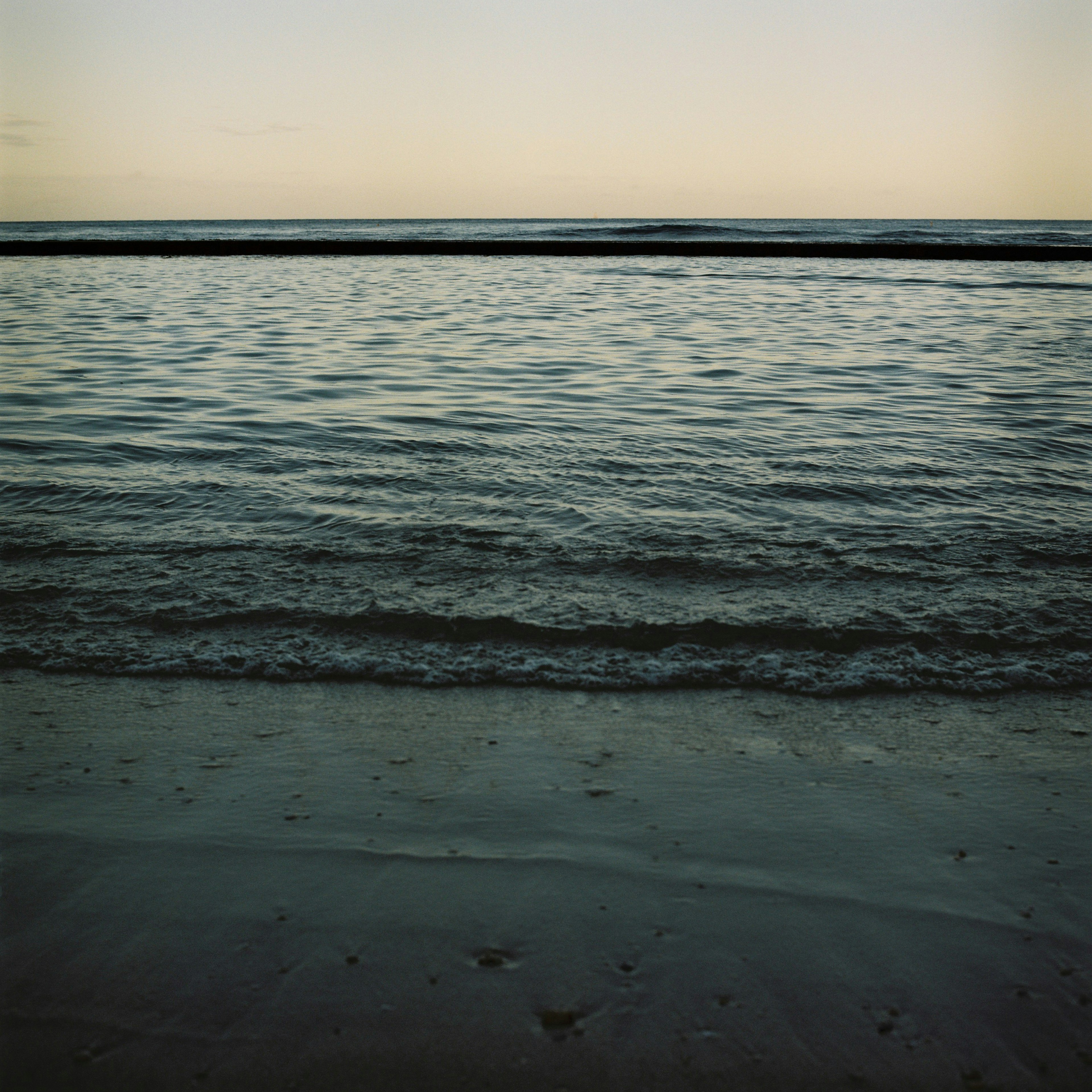 Calm sea landscape at sunset with gentle waves and serene water surface