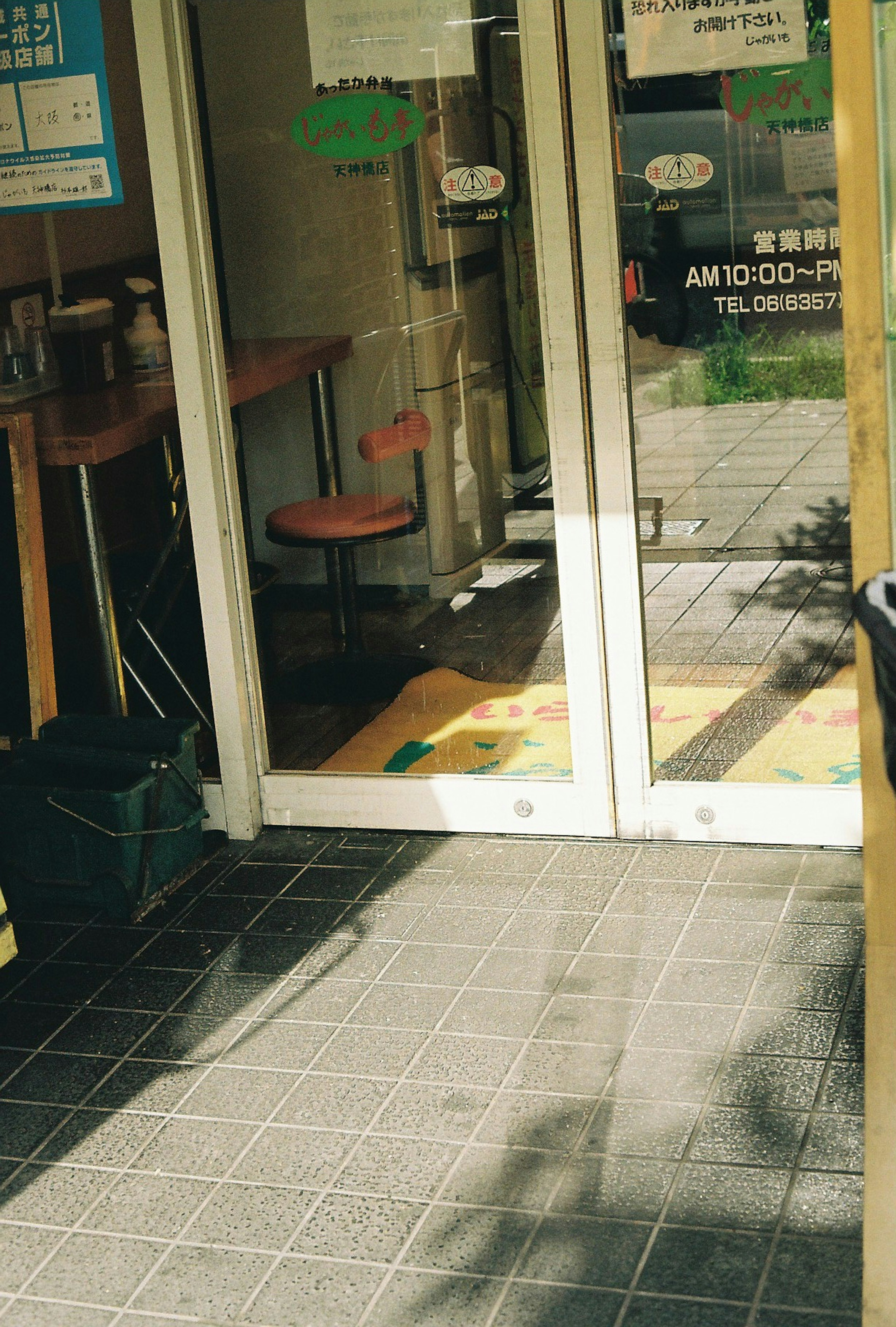 Foto de la entrada de una tienda con puertas abiertas e interior visible