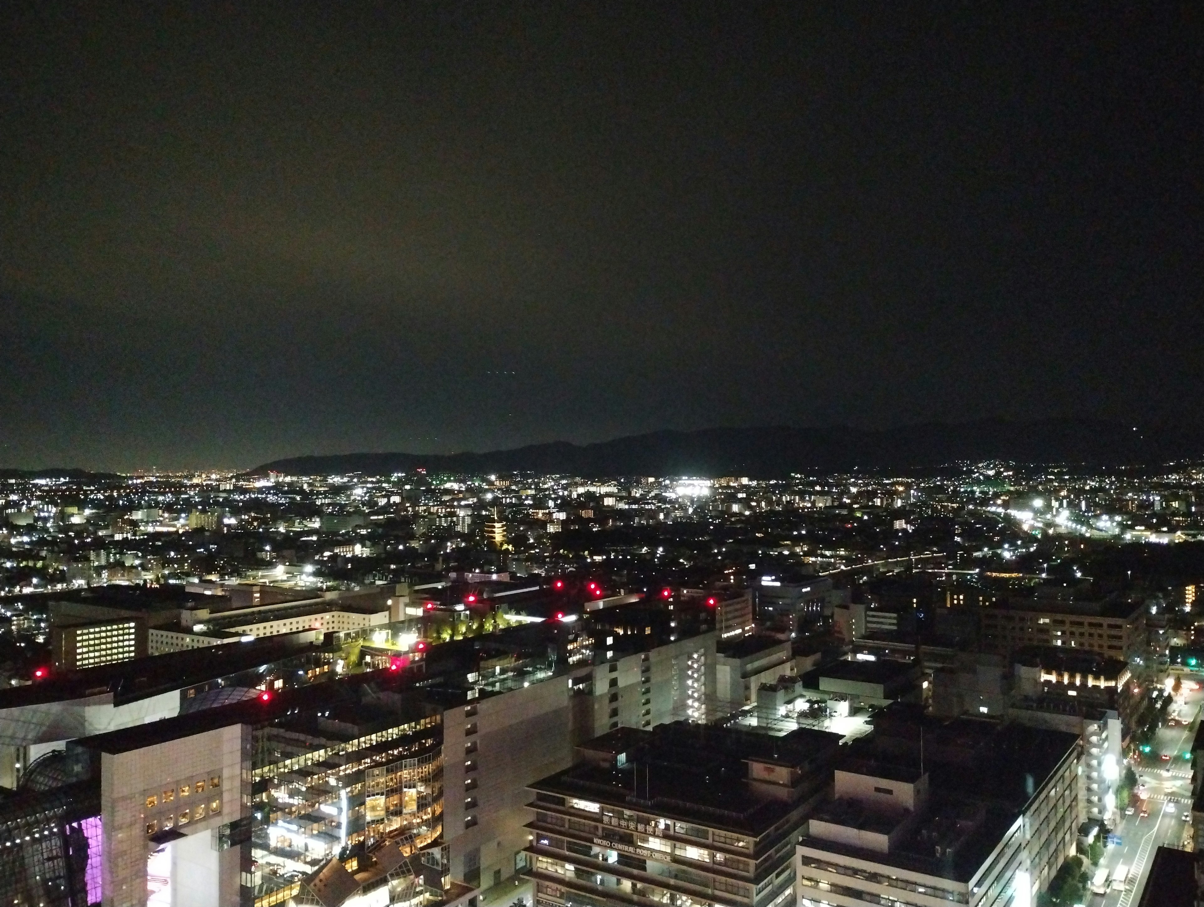 Vista panoramica di uno skyline cittadino di notte con edifici illuminati e luci