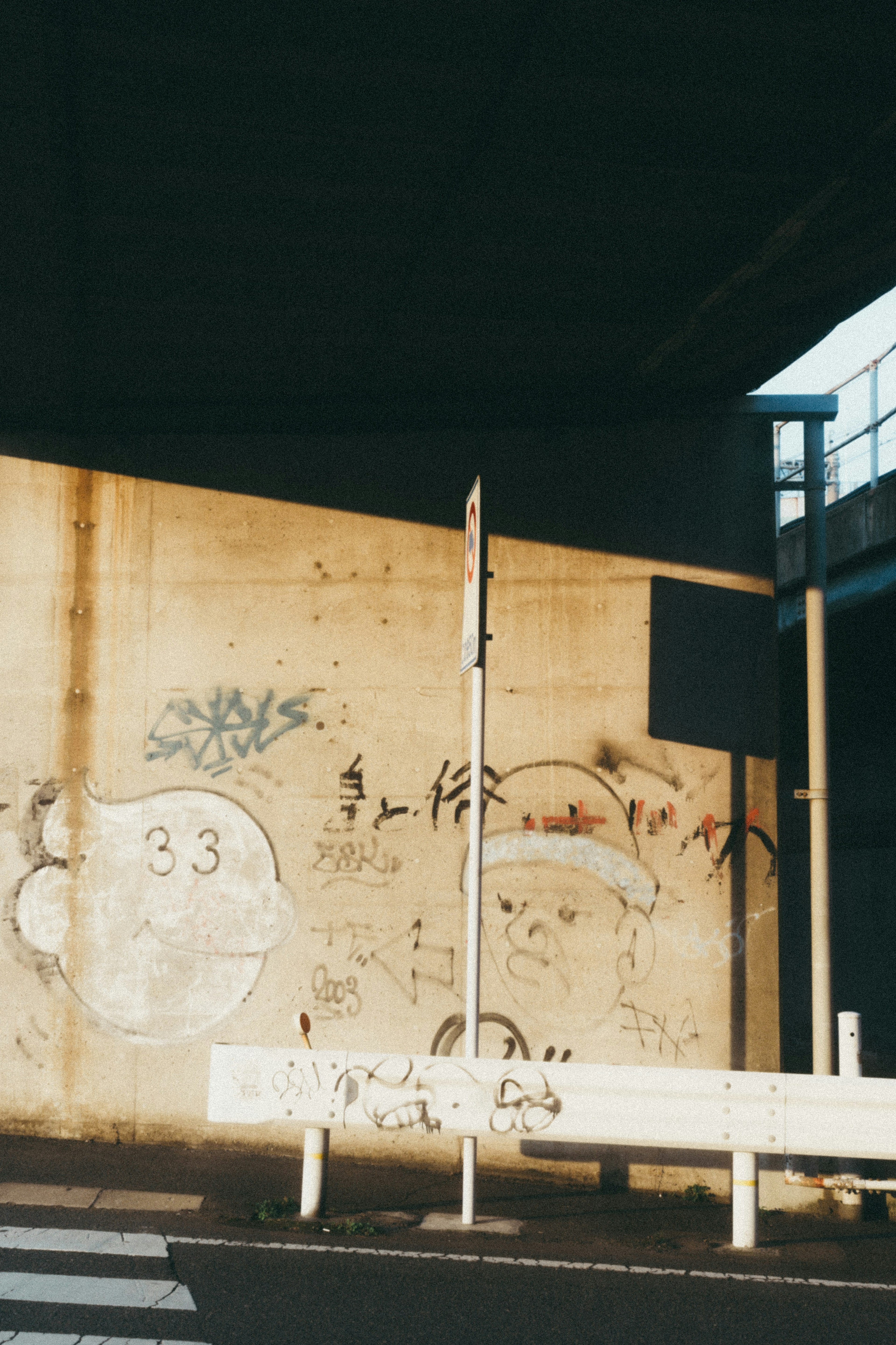 Scena urbana con un muro di cemento coperto di graffiti e un segnale stradale