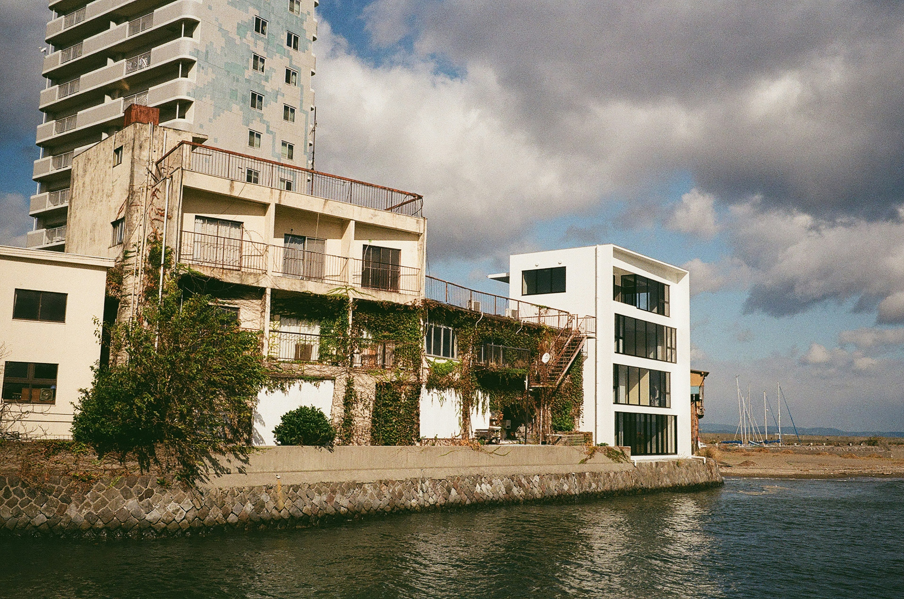 Kontrast zwischen einer alten Fabrik und einem modernen Gebäude am Wasser