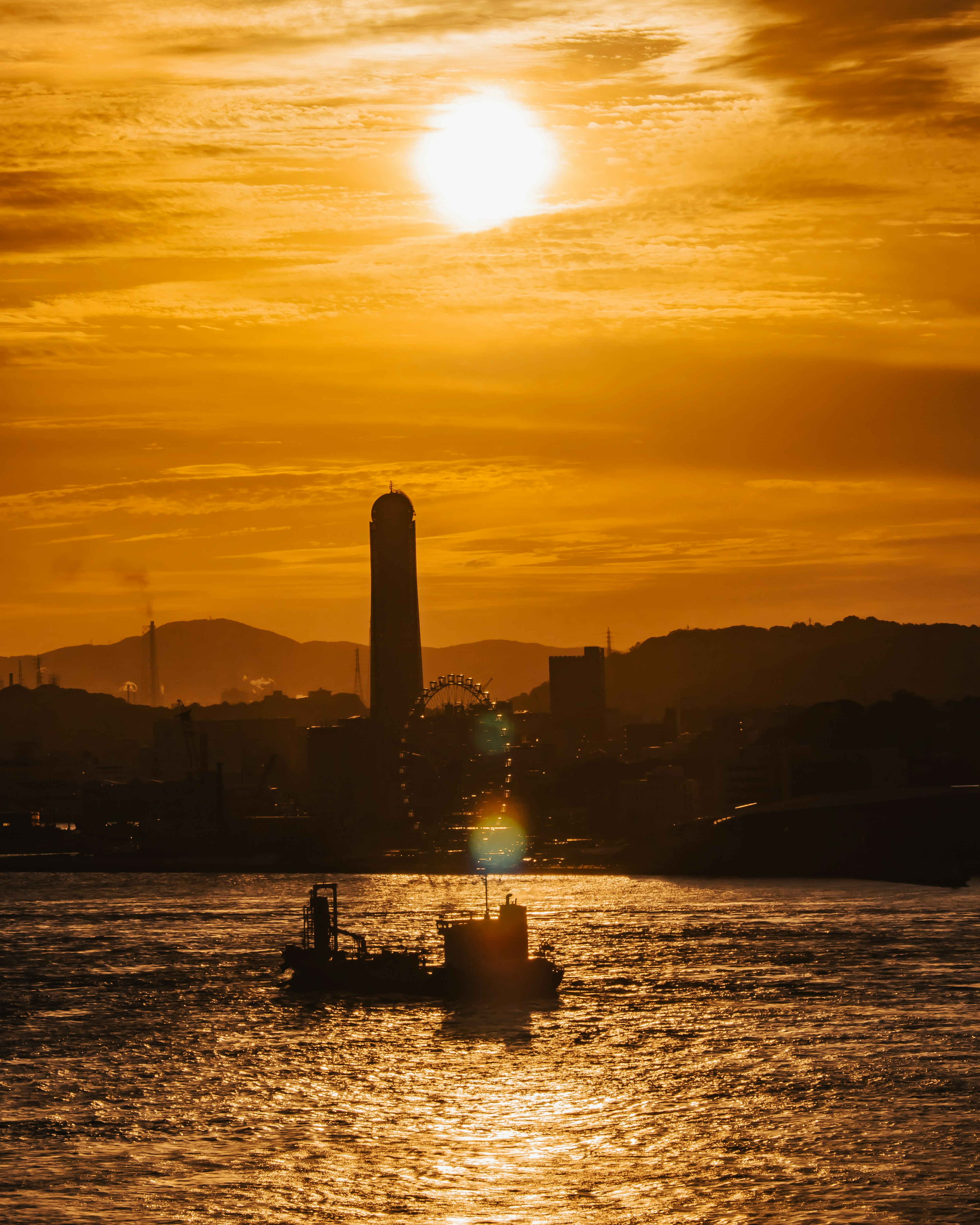 Vista panoramica di una barca su acqua scintillante sotto un tramonto dorato