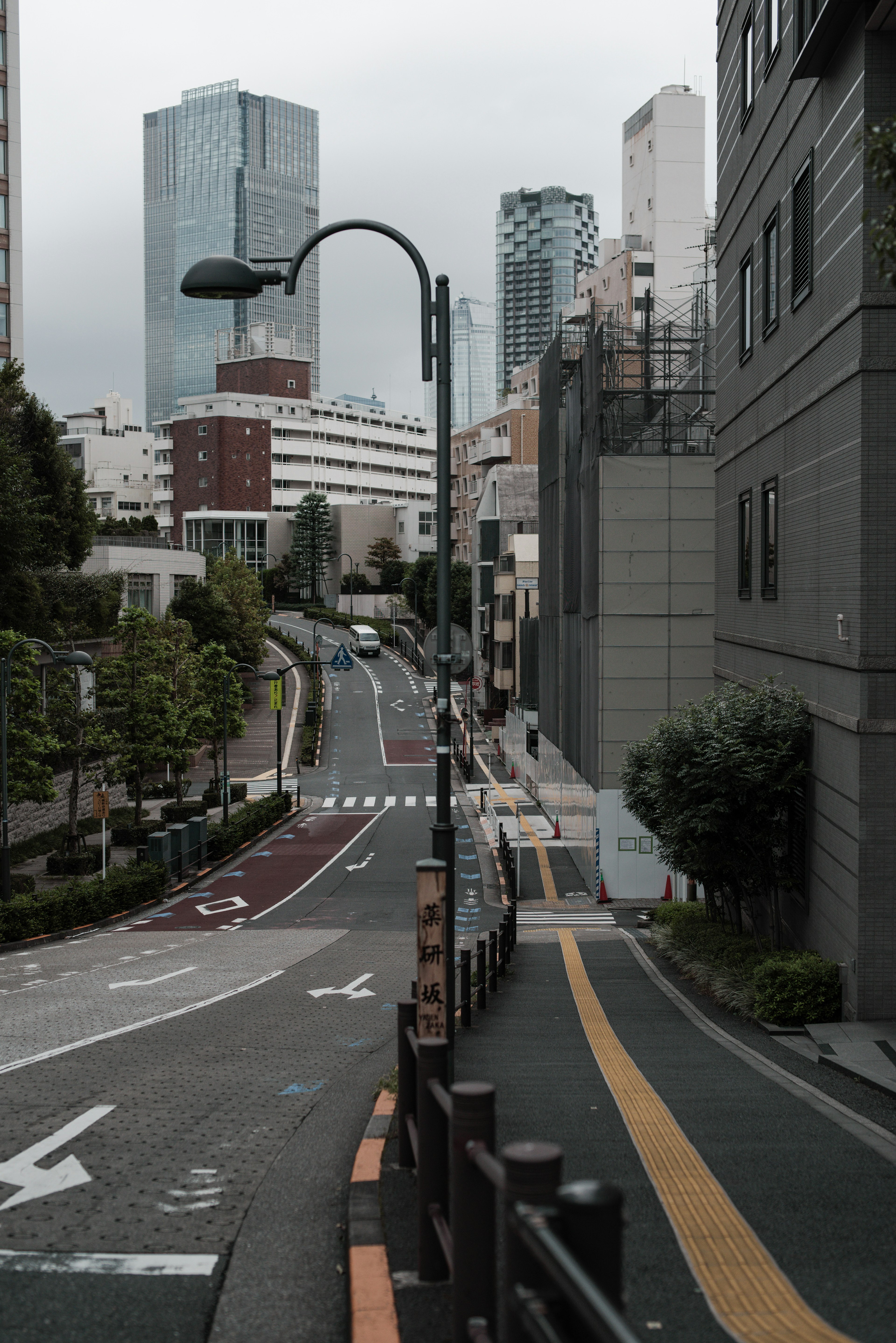 Una strada in pendenza che sovrasta il paesaggio urbano di Tokyo con grattacieli