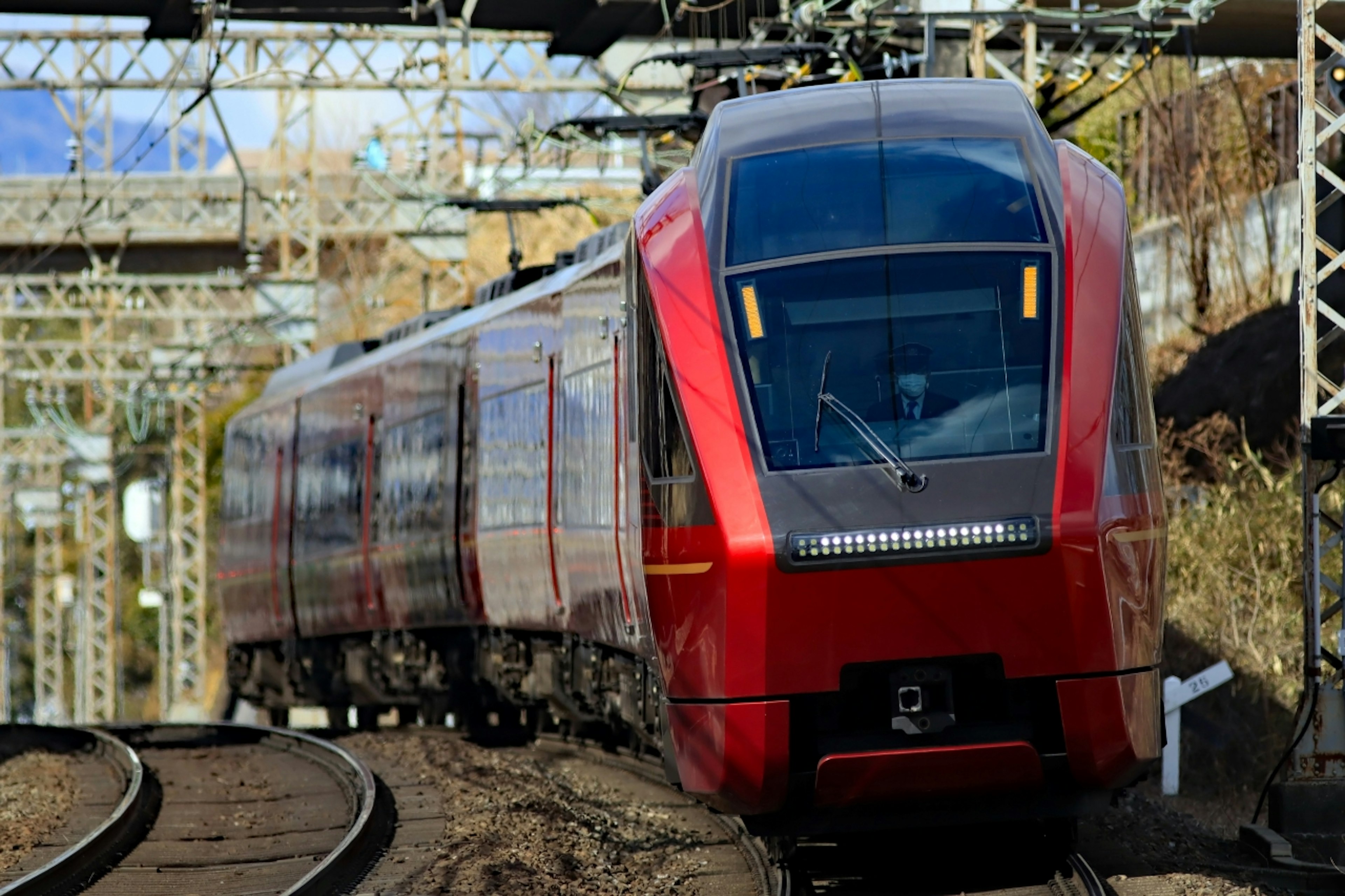 A modern red train traveling on railway tracks