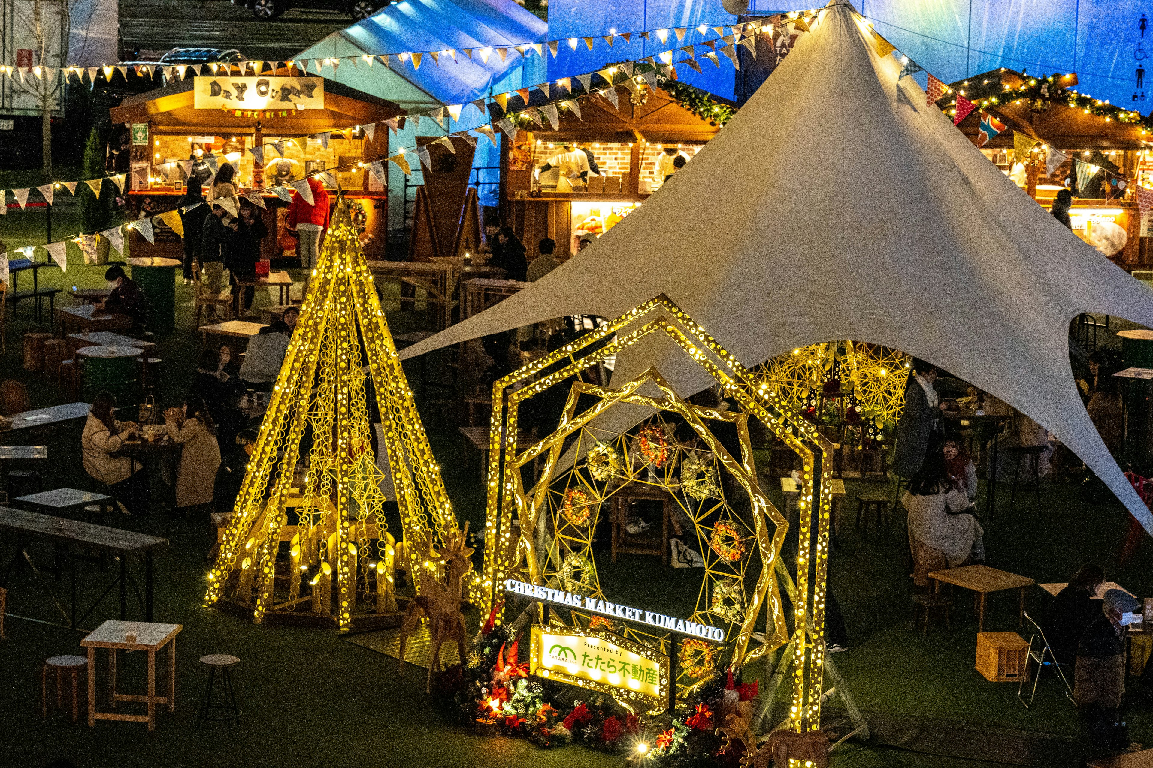 Scene of a Christmas market with decorated booths and sparkling lights