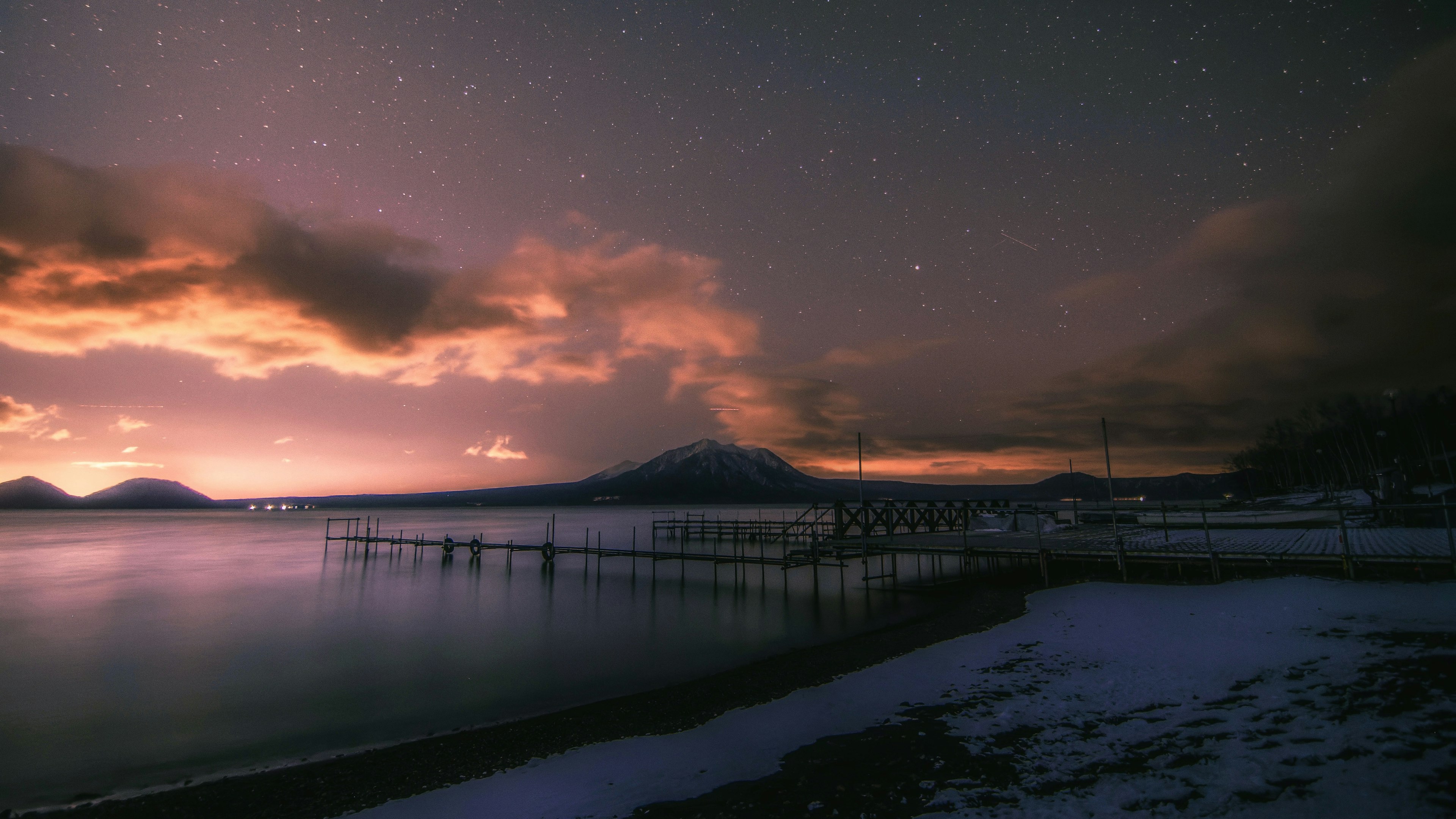 夜空に浮かぶ星々と雲が美しい湖の風景