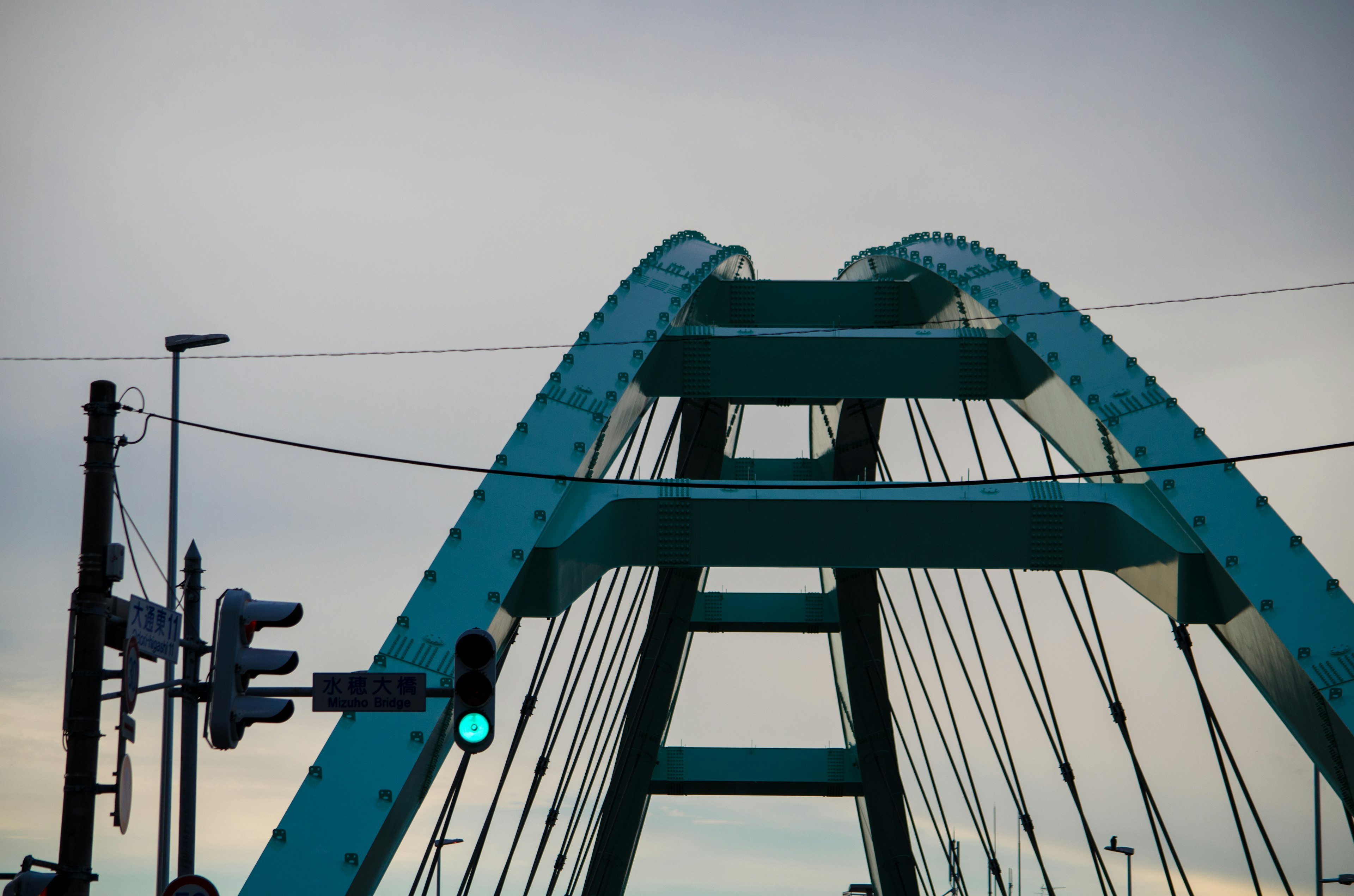 Struttura superiore di un ponte ad arco blu con semafori