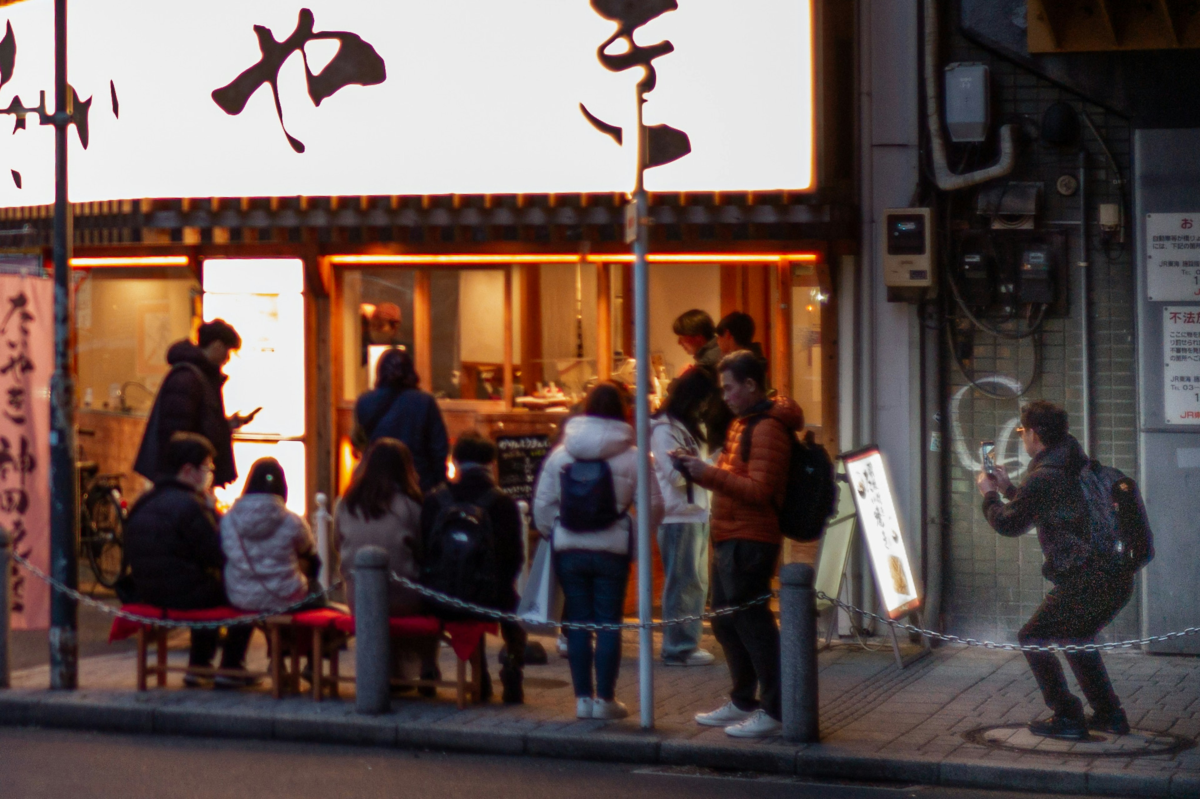 Belebte Restaurantfassade mit Menschen, die Schlange stehen und Essen genießen