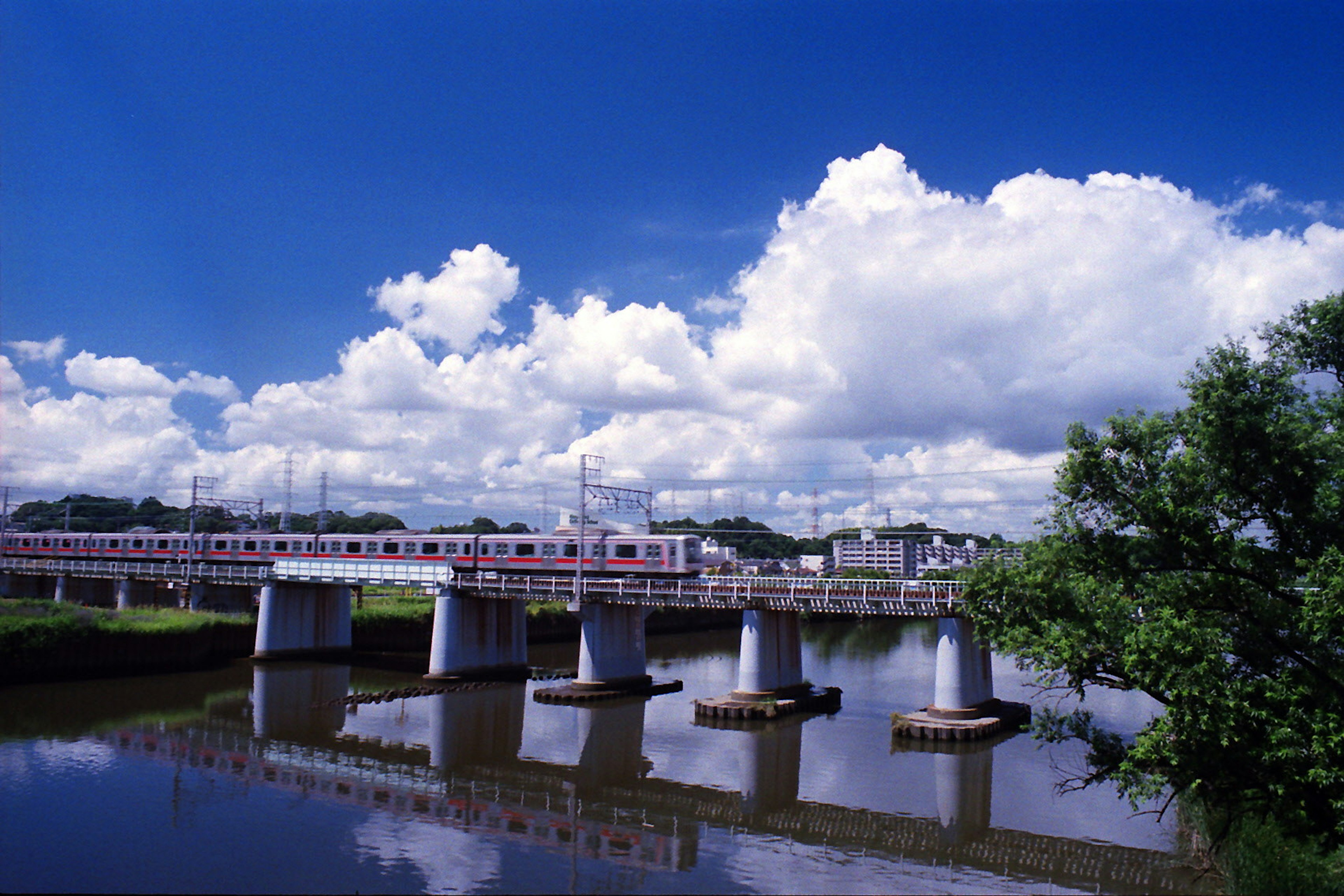 河上橋樑與火車在藍天和白雲下