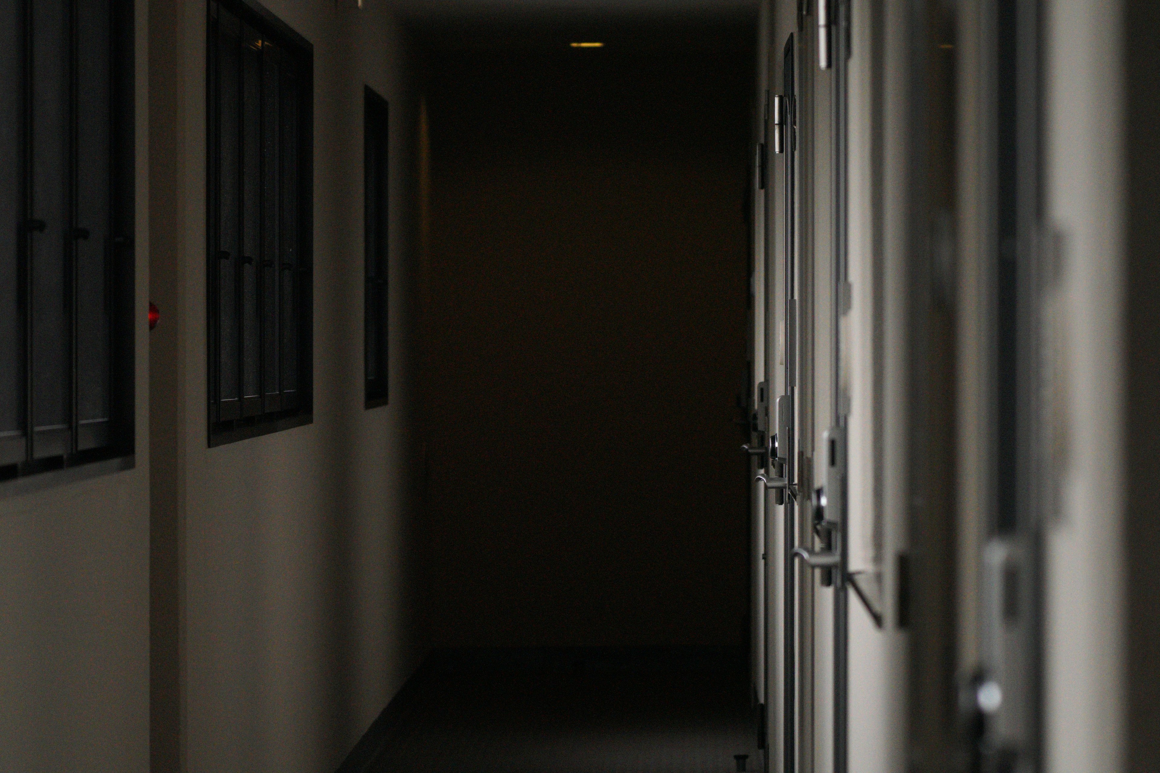 Couloir faiblement éclairé avec des portes fermées le long des murs