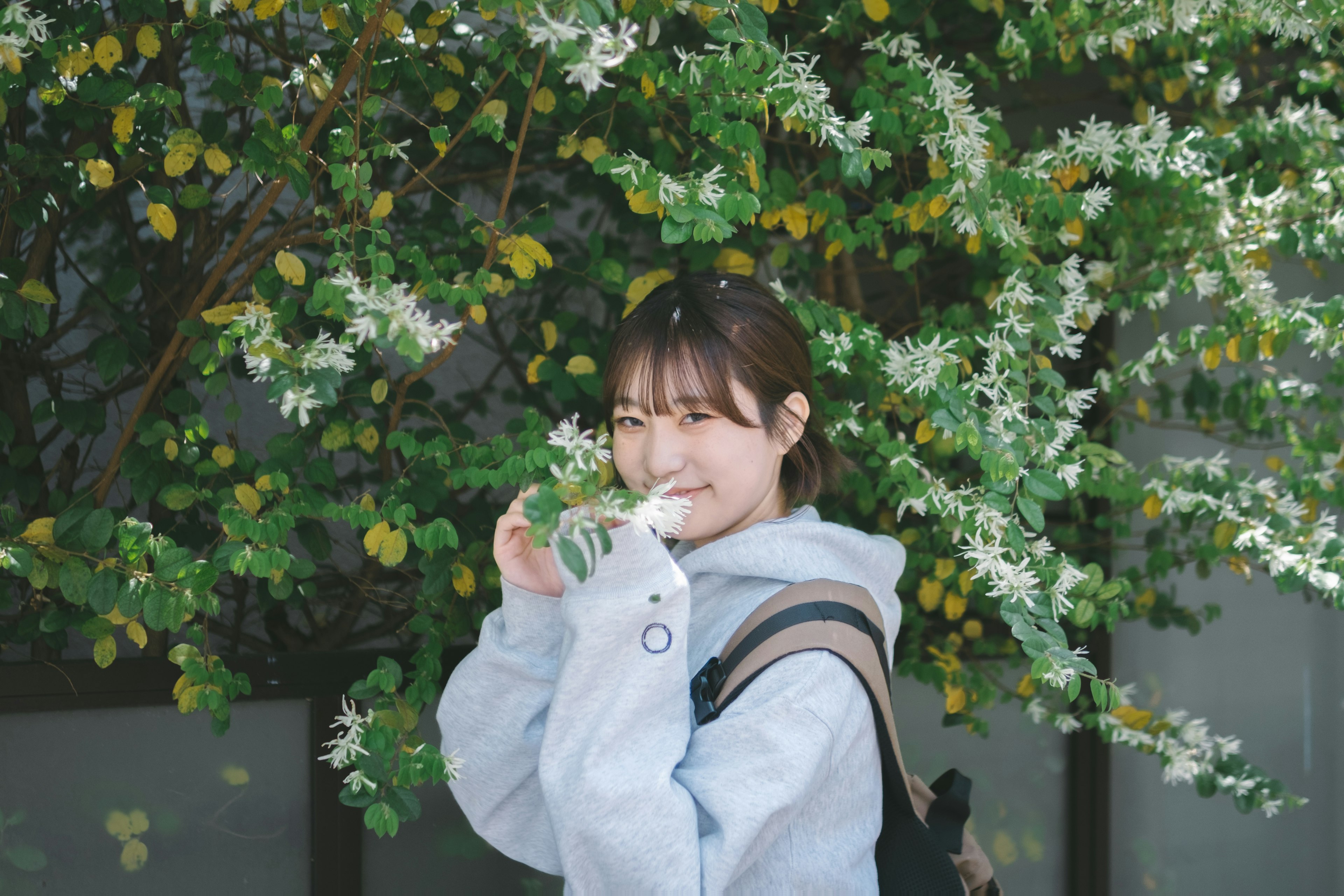 Femme jeune souriante entourée de fleurs