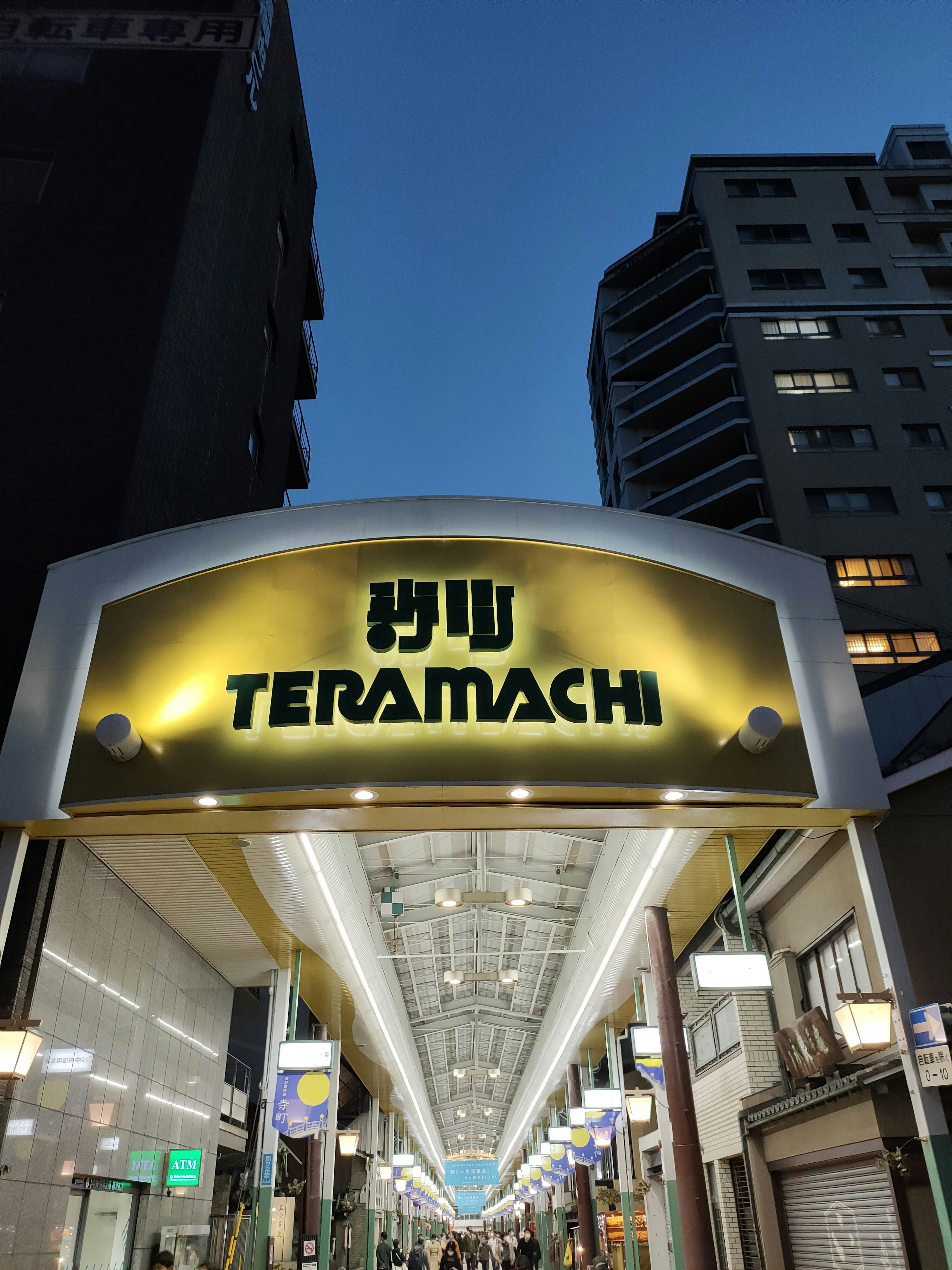 Archway sign of Teramachi shopping street illuminated at dusk