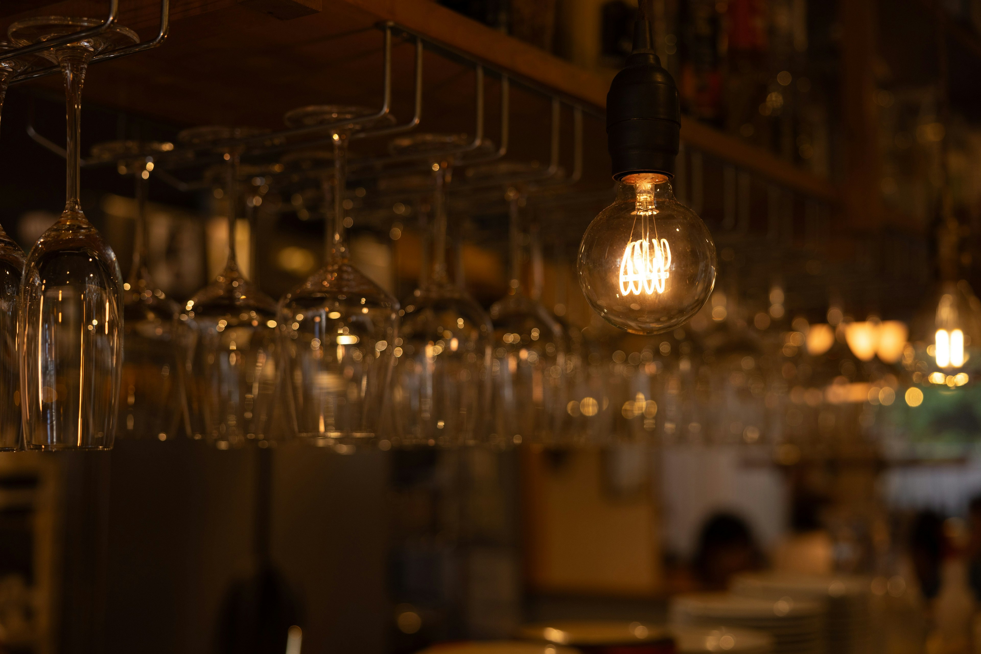 Hängende Gläser und warme Glühbirne in einer Bar