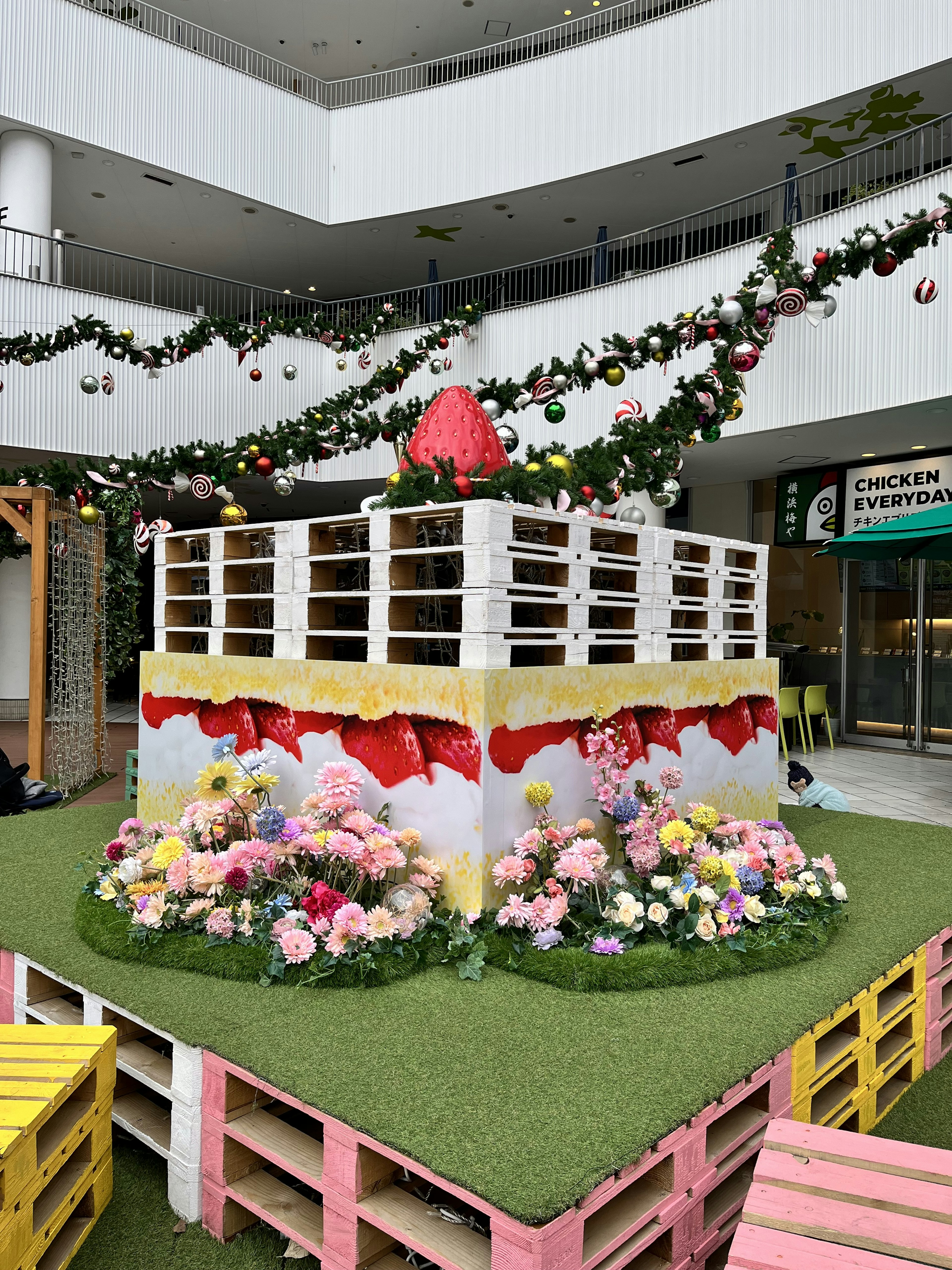 Plateforme décorative avec des fleurs colorées et de l'herbe verte dans un cadre festif