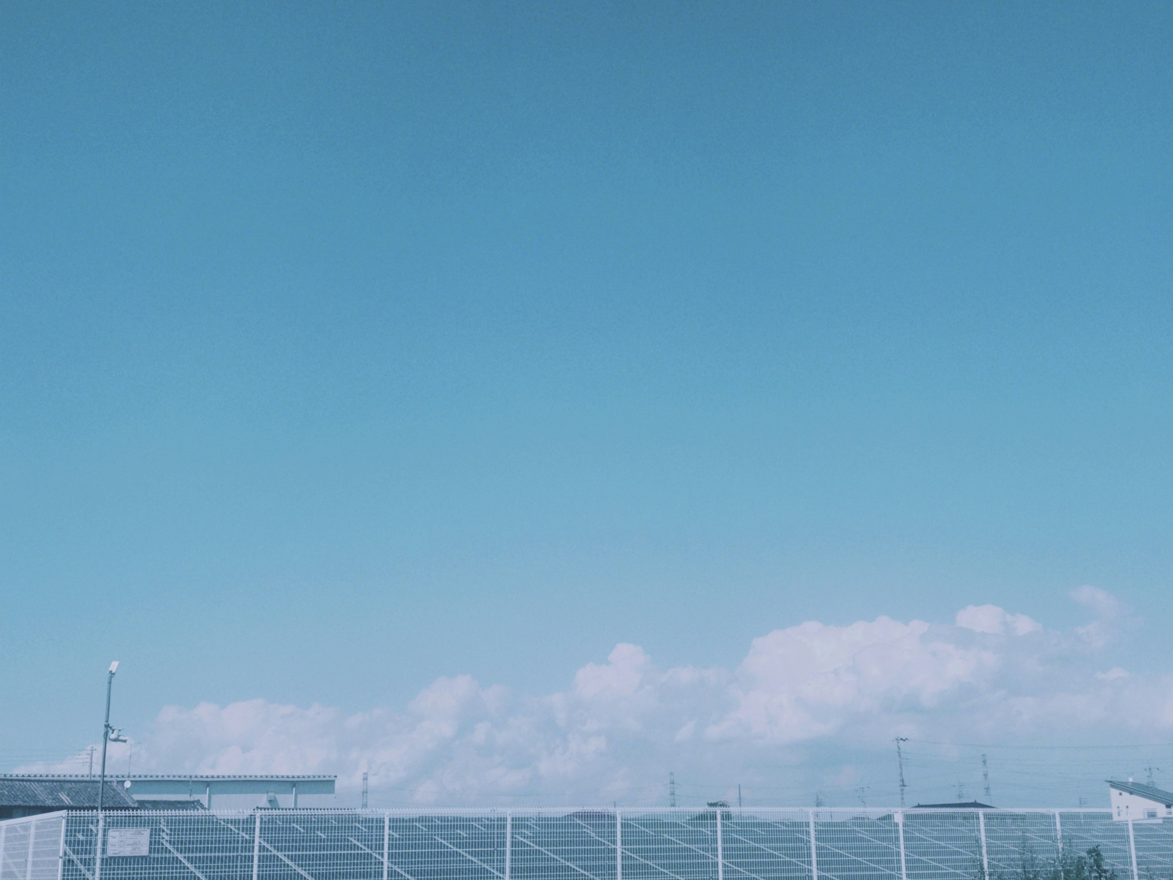 Paneles solares bajo un cielo azul claro con nubes blancas