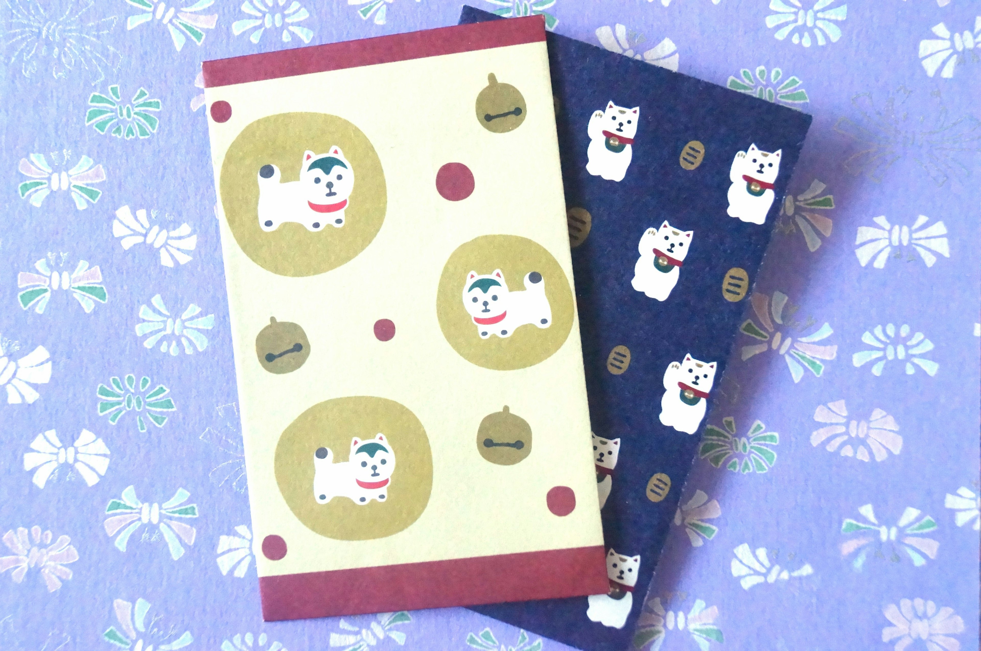 Two cute notebooks featuring illustrations of white dogs on a purple floral background