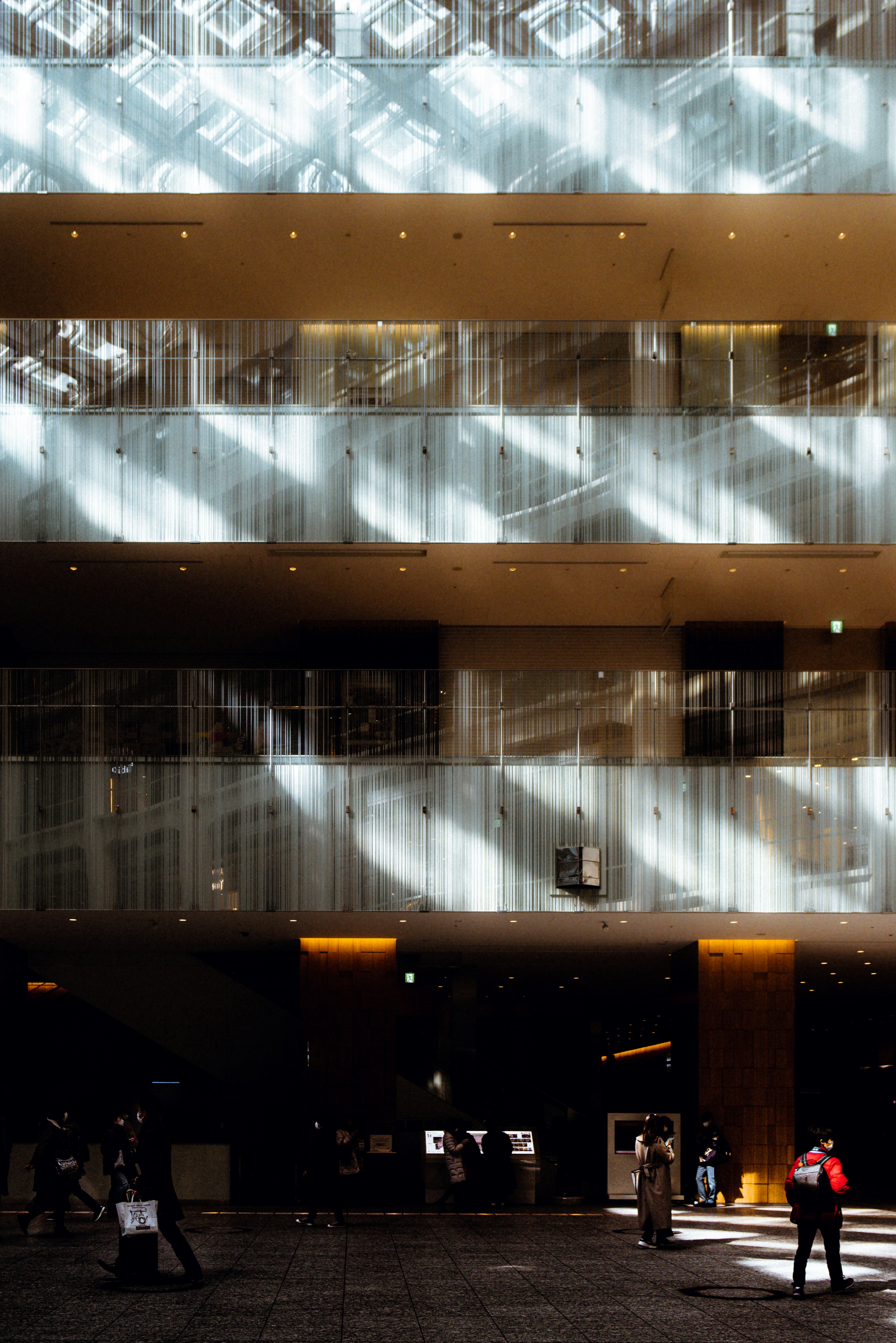 Interior de un edificio moderno con patrones de luz y personas