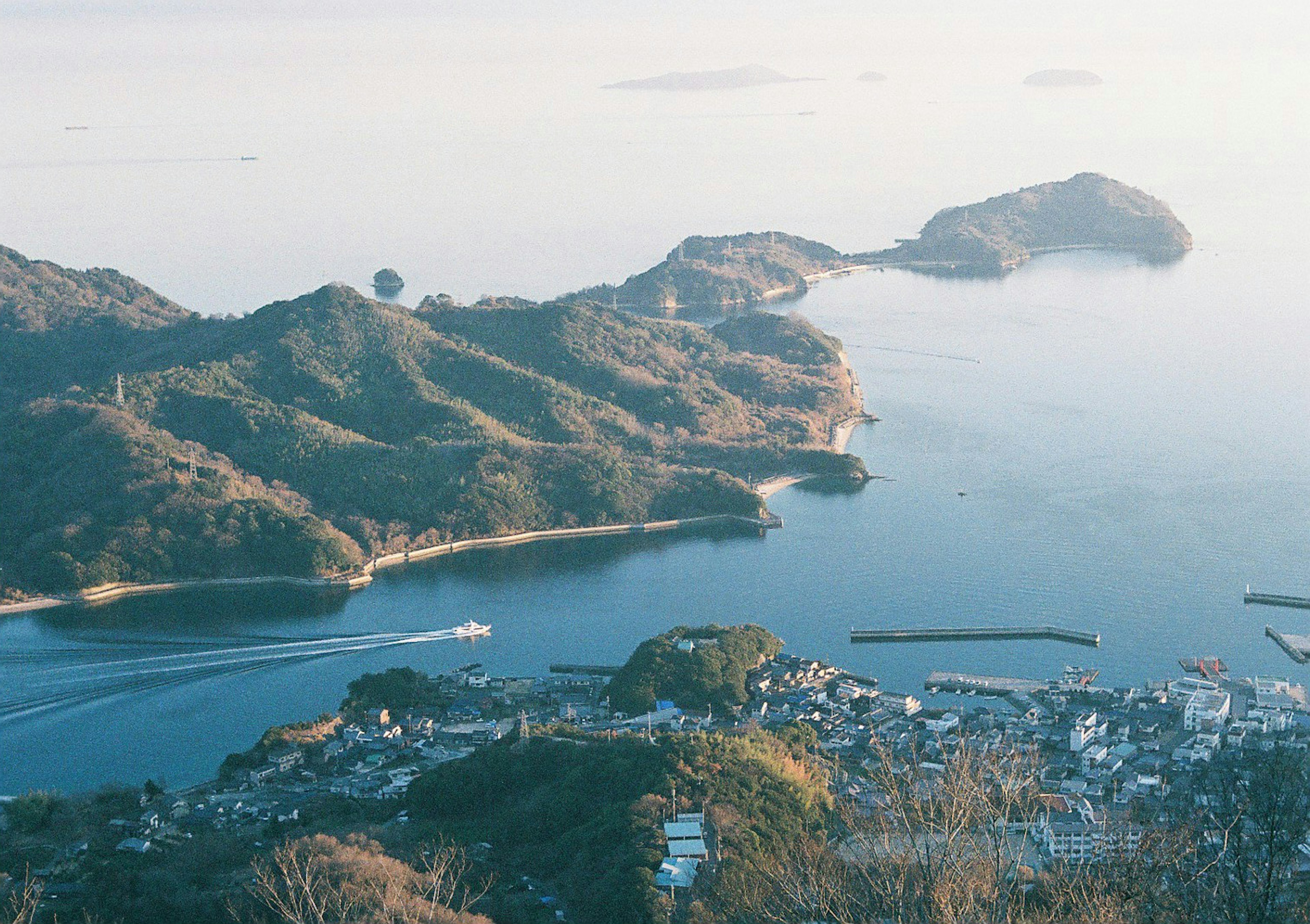 美丽的海洋和山脉风景 船在水面上滑行 沿海的城镇